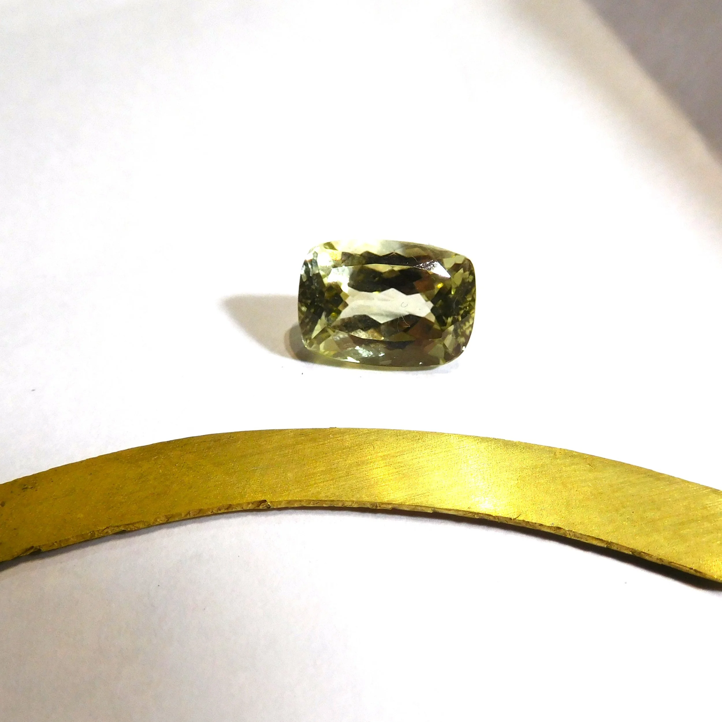 Cushion-cut hiddenite selected for a bespoke yellow gold and platinum dress ring
