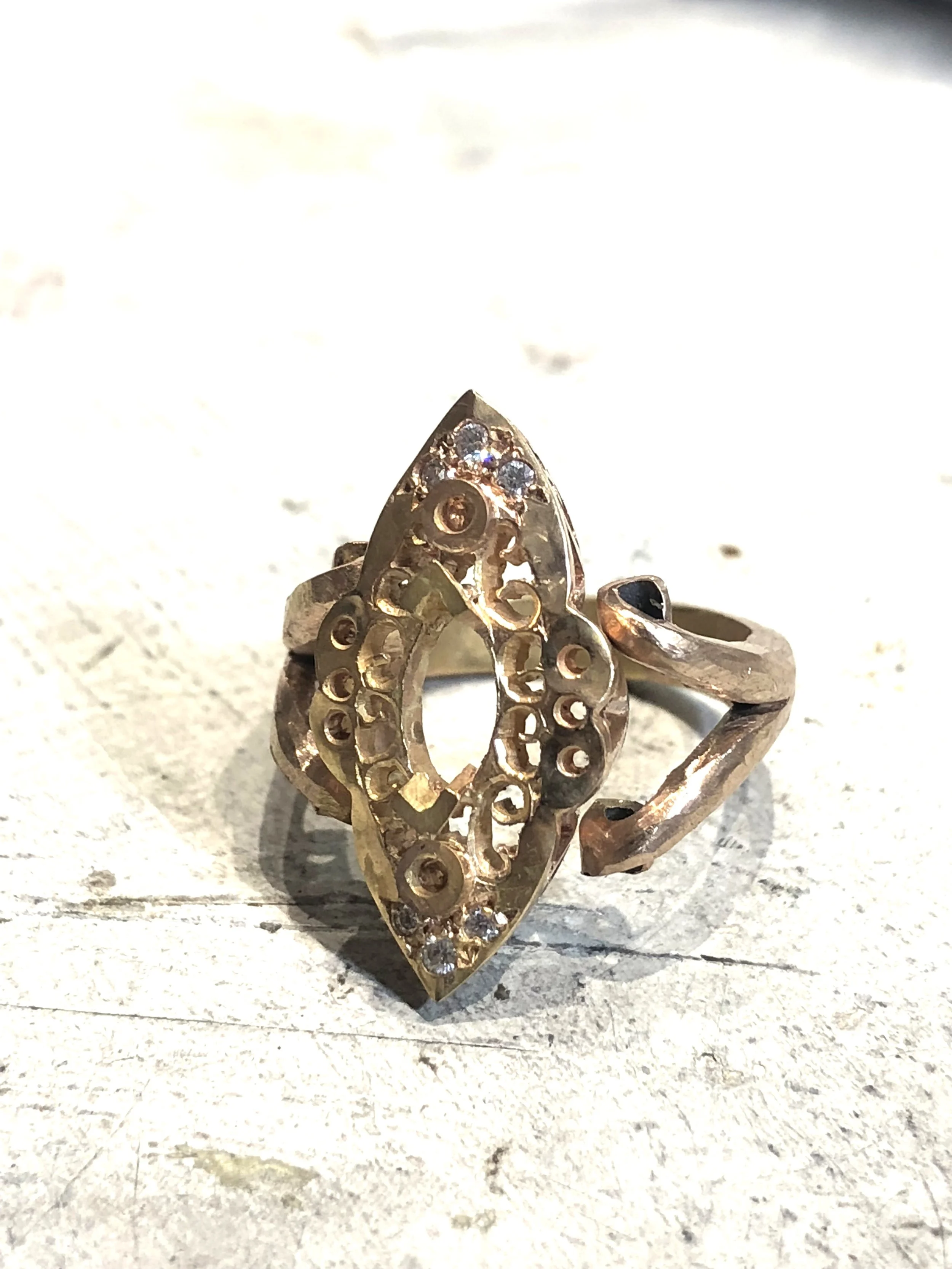 Hand-fabricated rose gold ring with pierced gallery and diamond settings before final stone setting