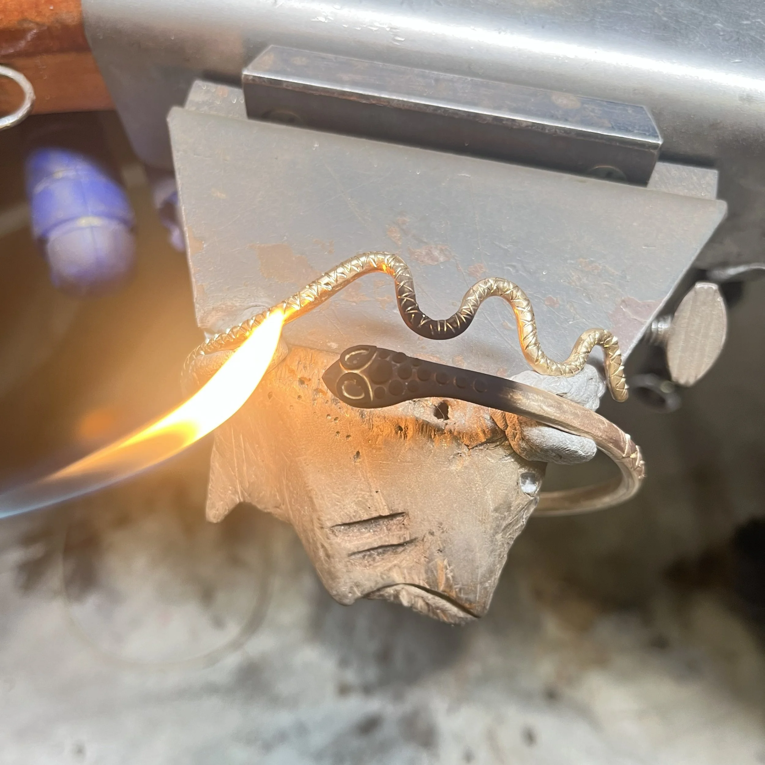 Hand fabrication of a gold snake cuff at the jeweller’s bench