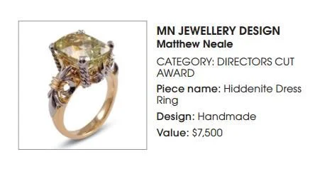 Handmade gold ring featuring a large, hiddenite gemstone in a designer presentation.