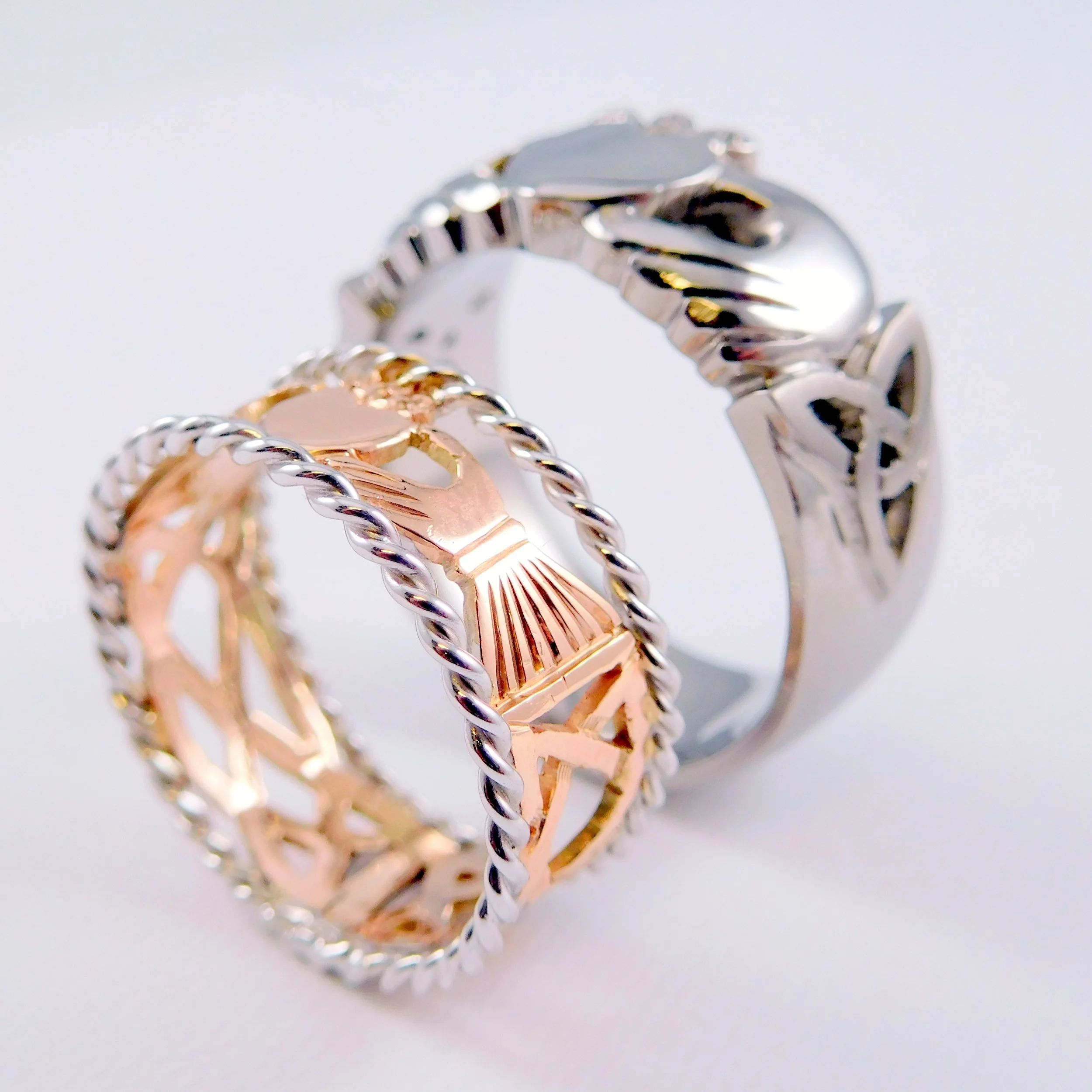 Close-up of intertwined celtic claddah gold rings with a decorative twisted design.