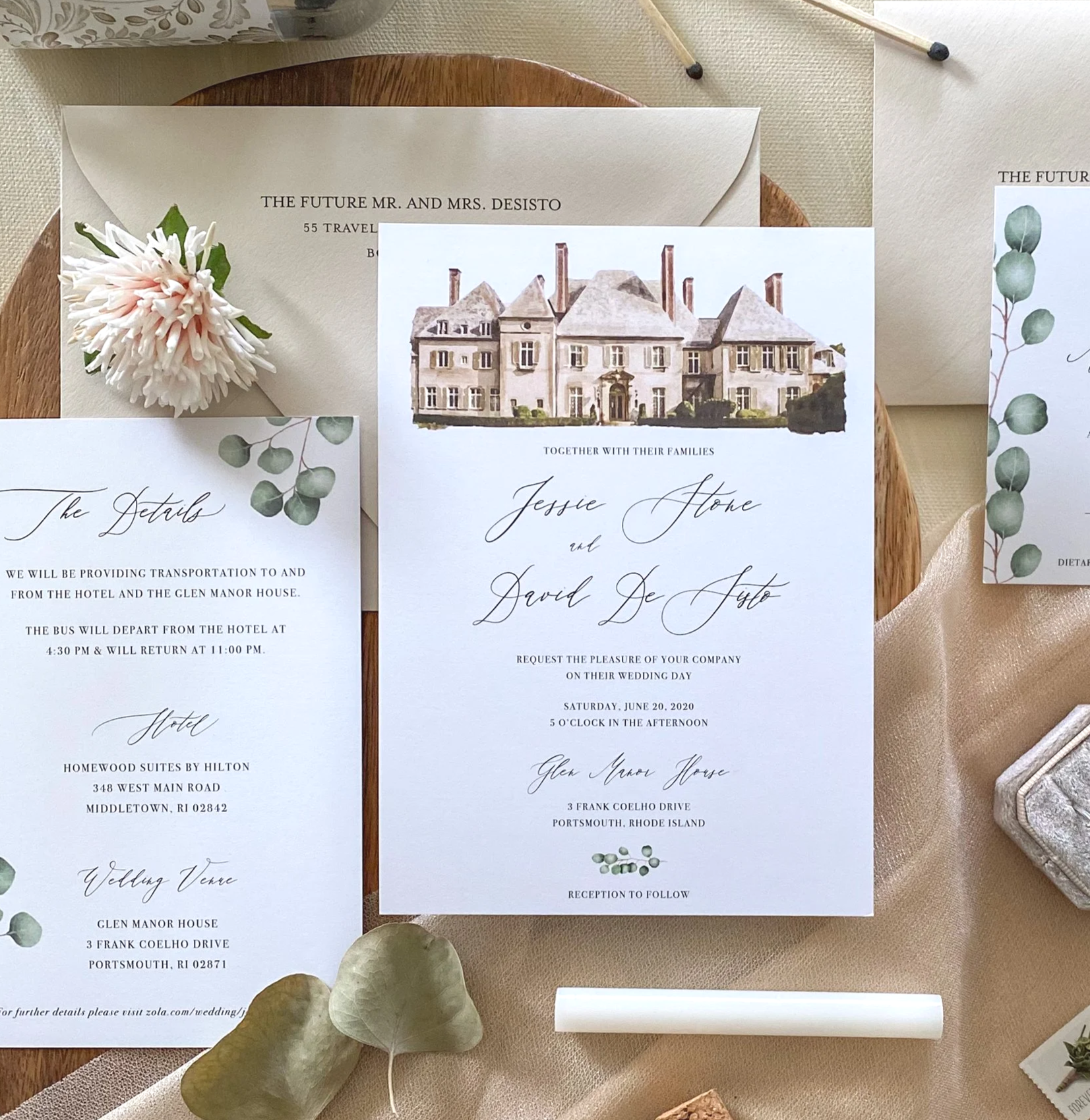 Wedding invitation suite with a large floral embellishment, greenery, and illustrated photos of a mansion, including the details of the wedding day.
