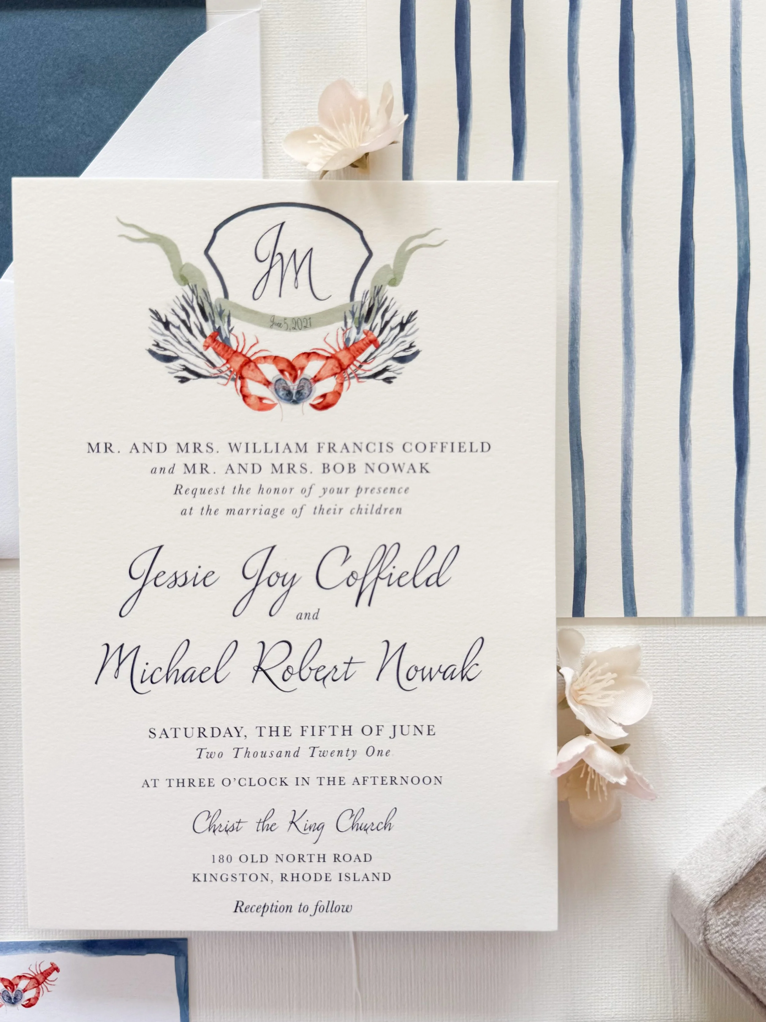 Wedding invitation with navy blue and white design, featuring lobster and shell illustrations, and elegant script text with details of the bride and groom's wedding.