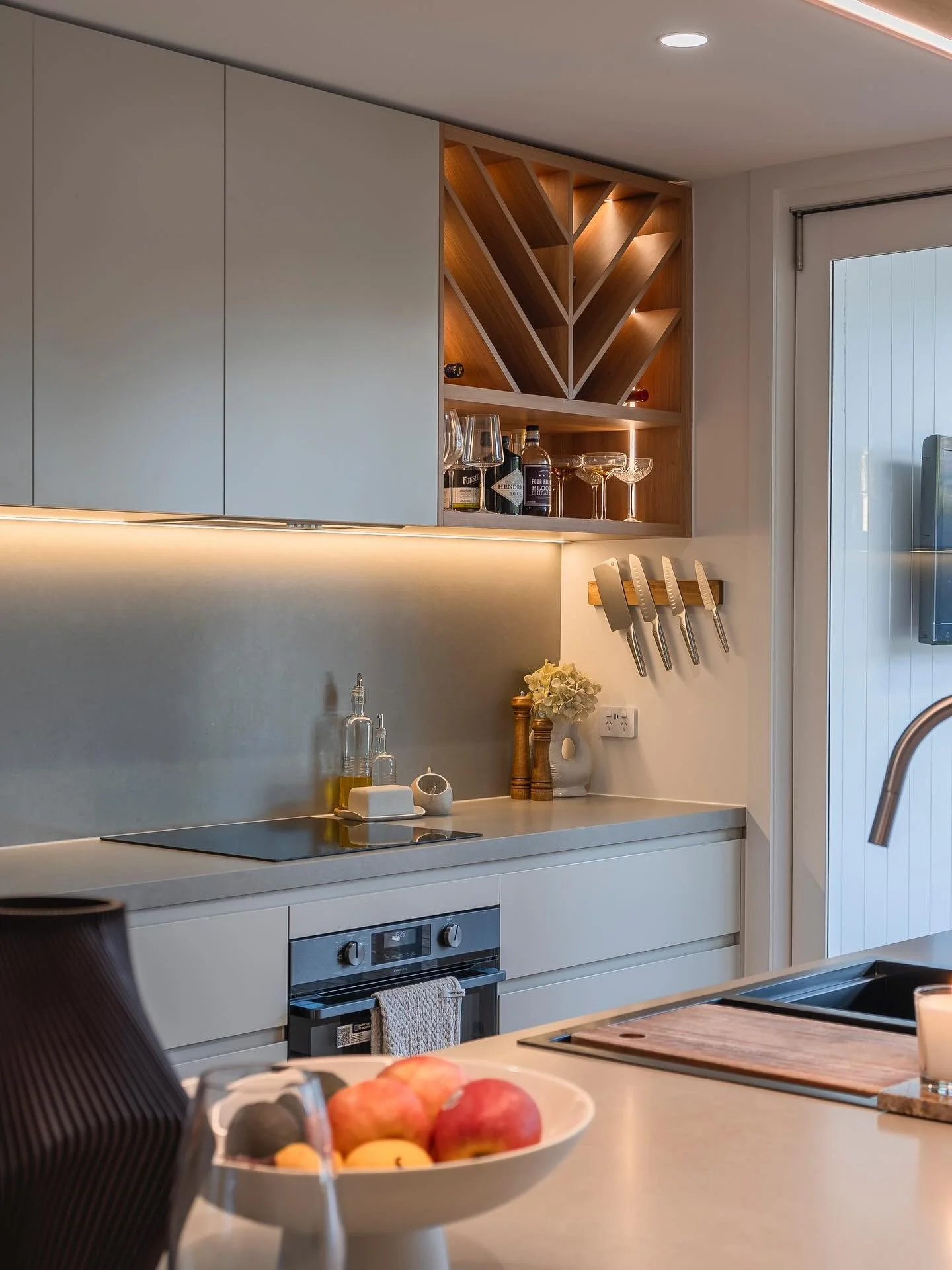 Slick, grey finishes with warm timber highlights in a modern kitchen renovation