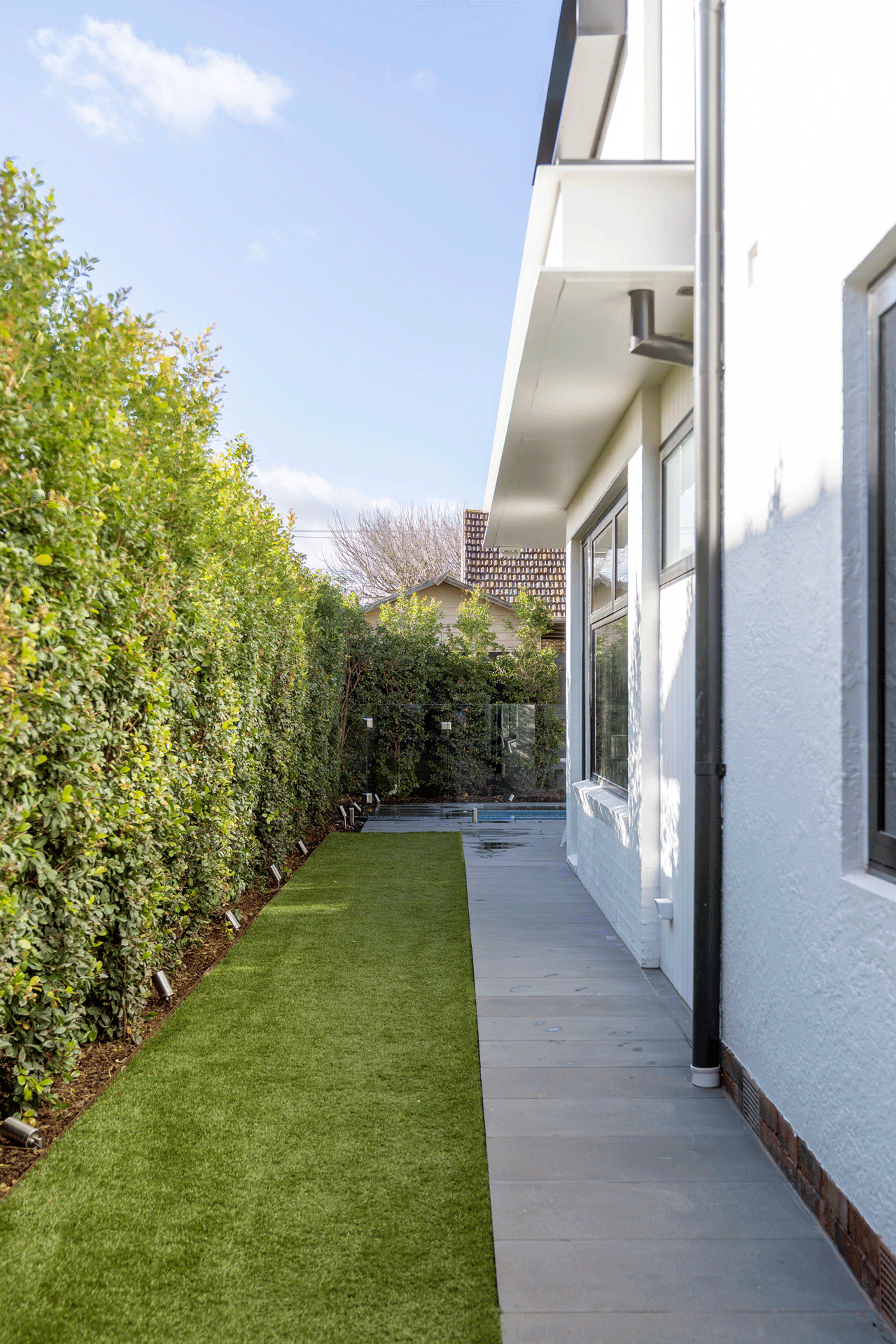 Image looking down the side of a renovated house with landscaping and clean finish