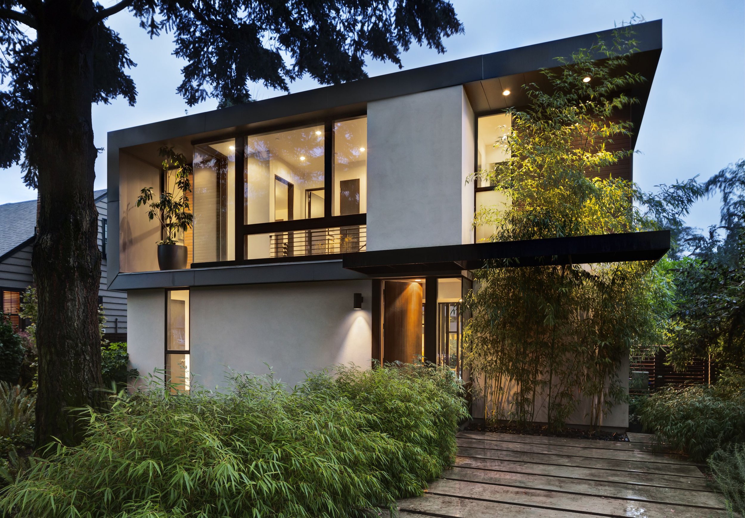 The facade of a modern contemporary suburban home with dynamic structure and beautiful landscaping