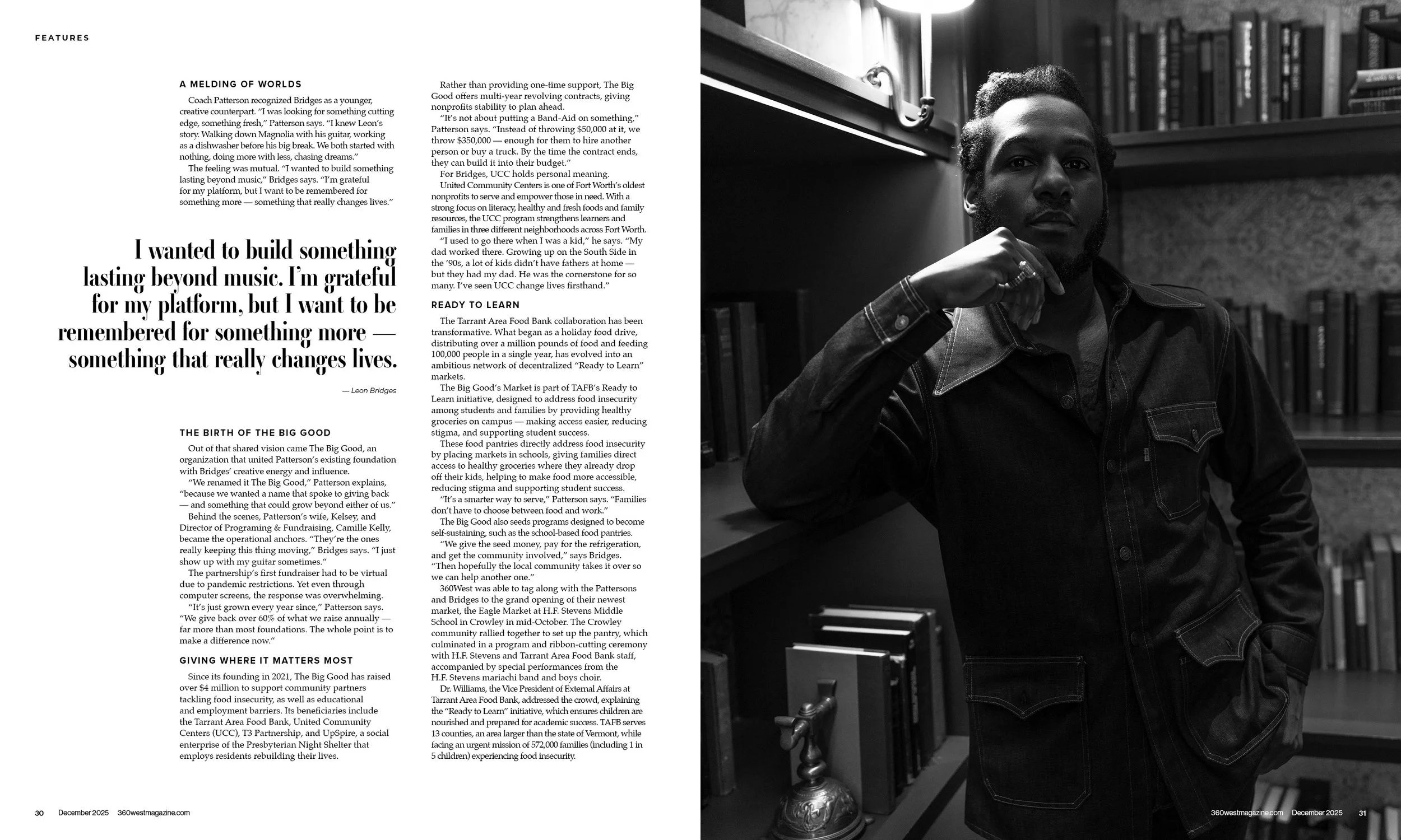 A black and white photograph of a man with short curly hair, wearing a denim jacket, sitting in a room with bookshelves and a lamp, resting his chin on his hand.