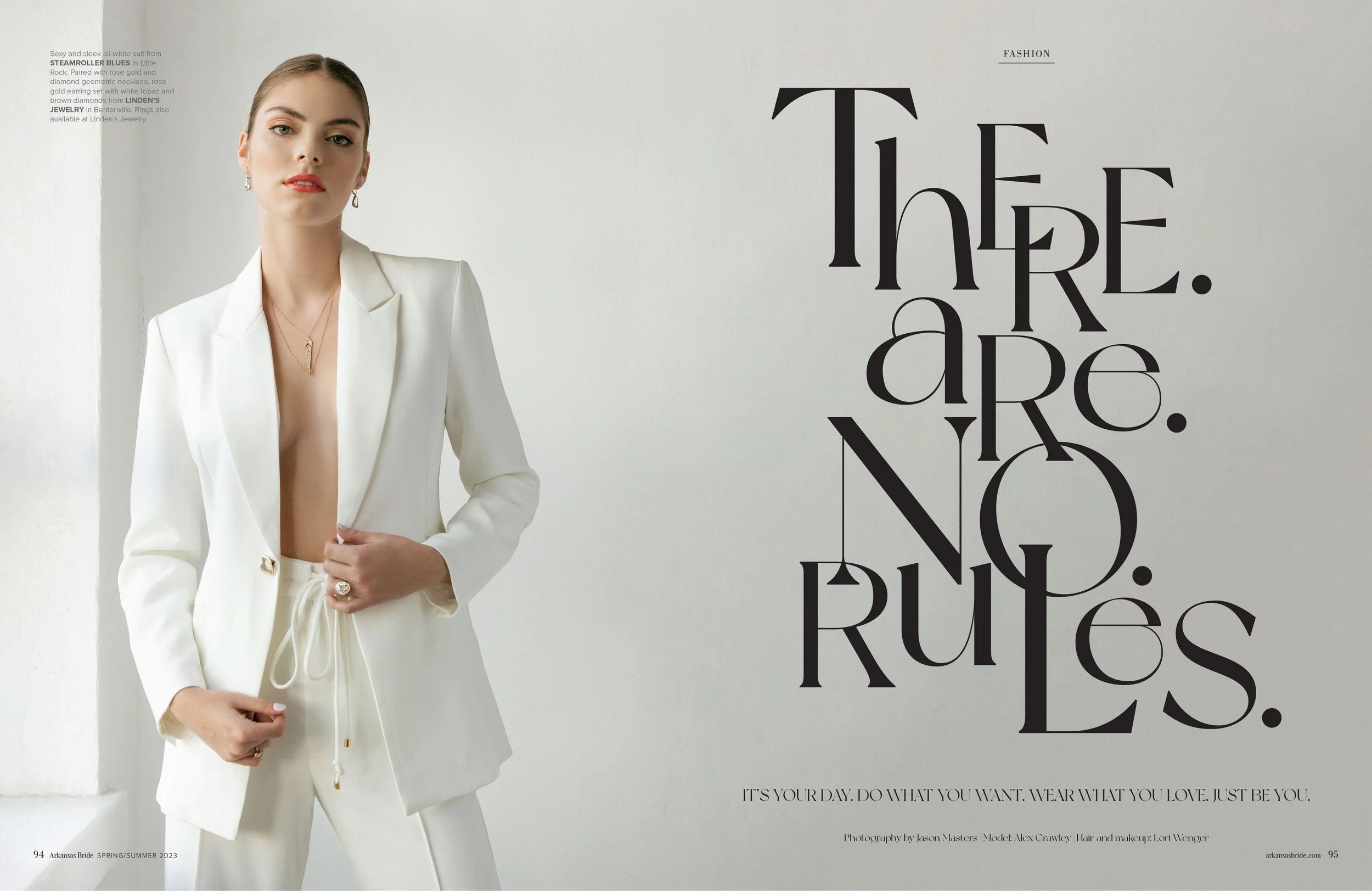 A woman in a white suit with an open blazer shows her chest, wearing jewelry and standing in front of a white wall, with the text 'There. Are. No. Rules.' written in large black letters beside her.
