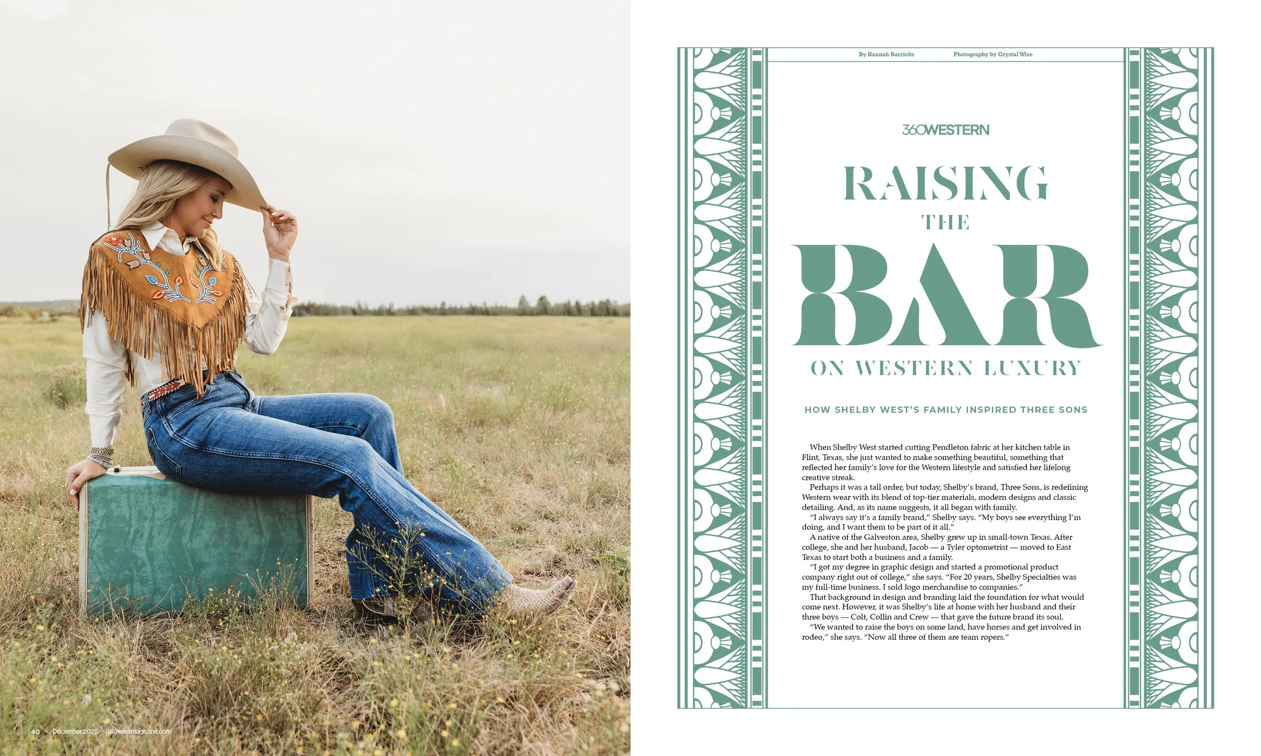 A woman dressed in a western outfit with a fringed embroidered shawl, blue jeans, and a cowboy hat, sitting on a TV case in an open field, looking down and holding her hat brim.