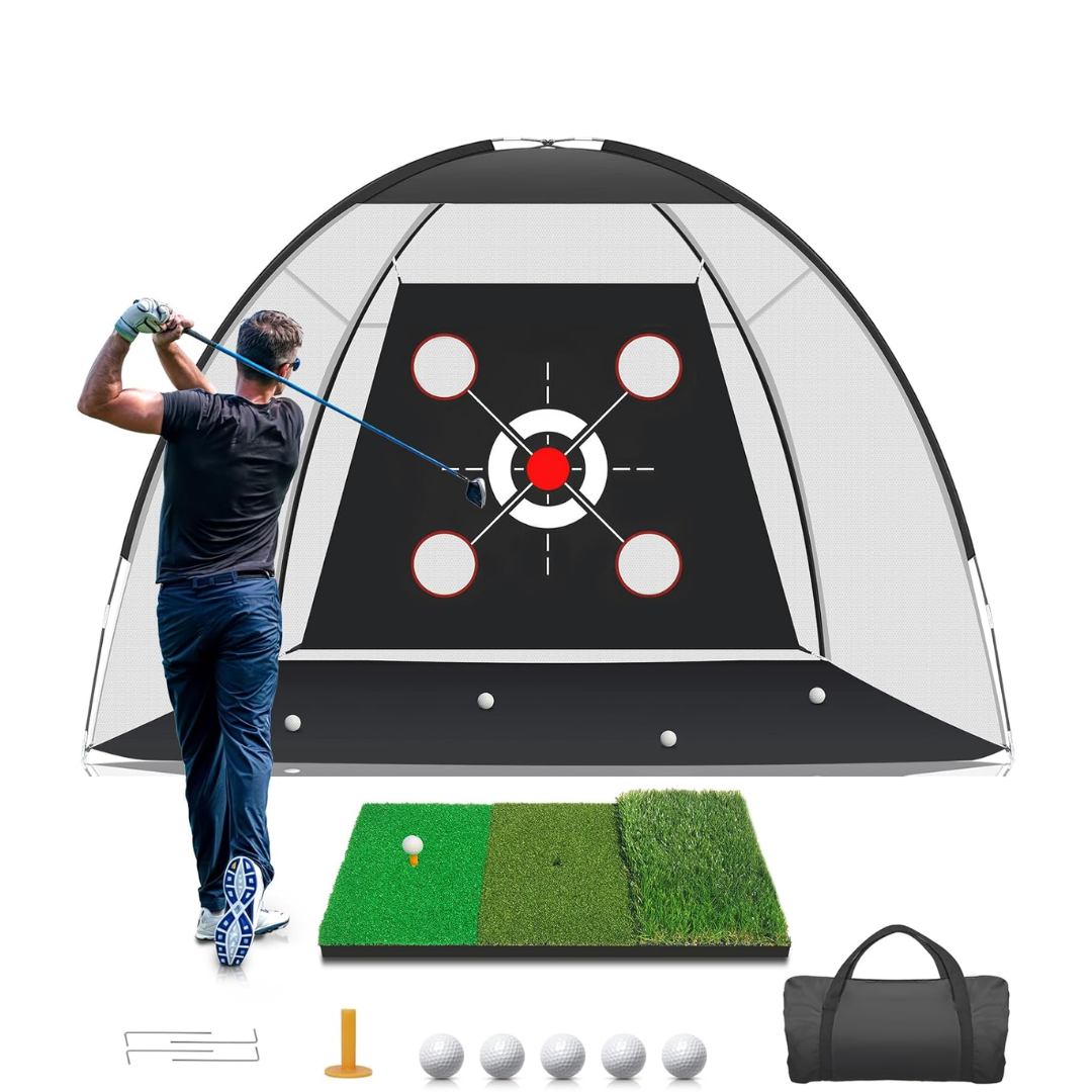 A man practicing golf indoors using a golf hitting net, hitting a golf ball on a turf mat with a golf bag nearby.