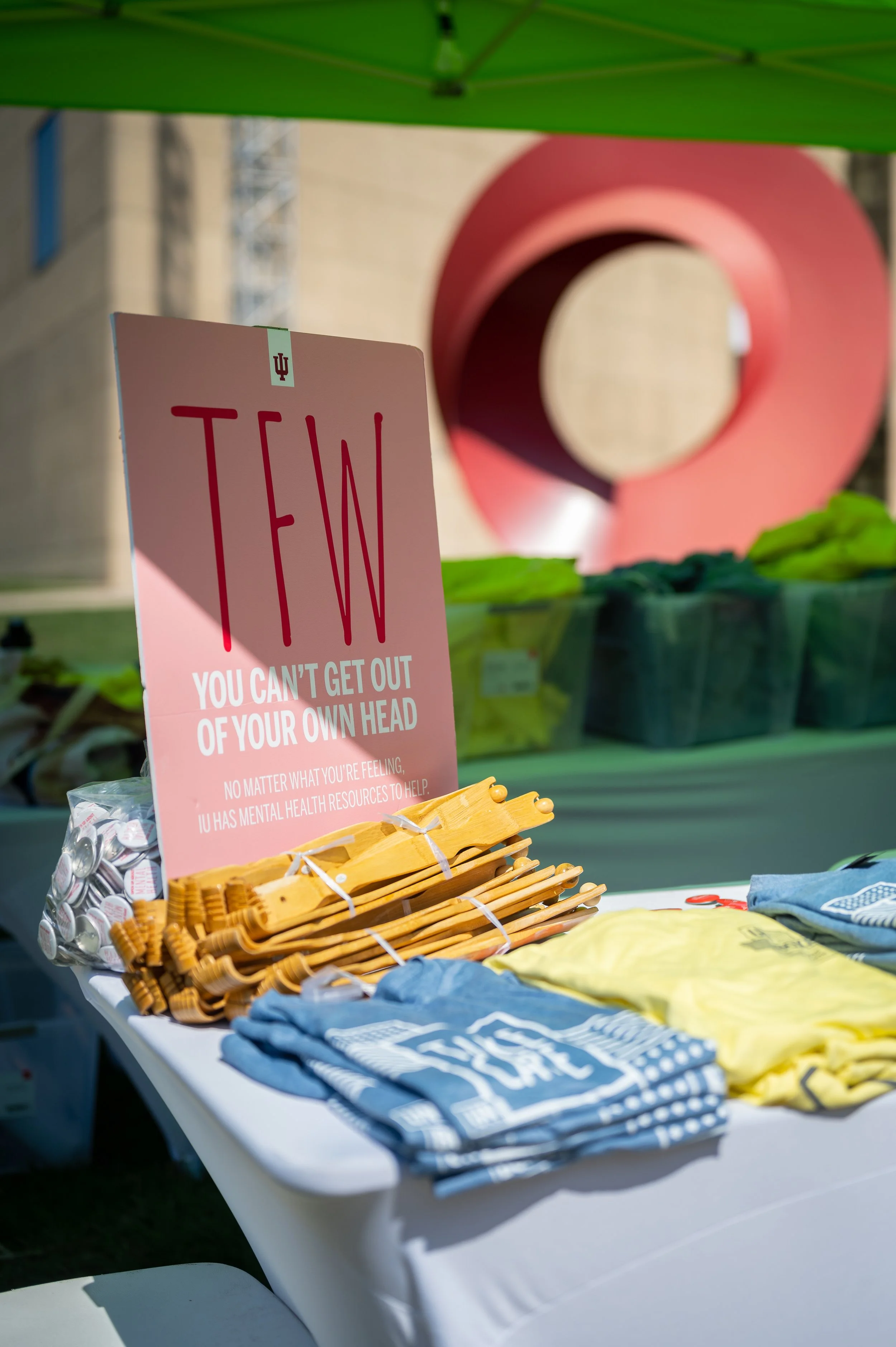 stacks of blue and yellow t-shirts and a poster on a table