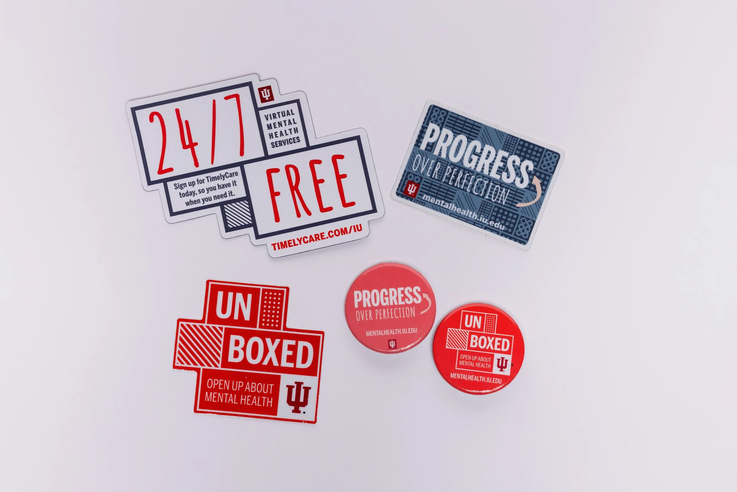 Collection of colorful social media stickers and buttons promoting mental health awareness, including phrases like '24/7 Free,' 'Progress Over Perfection,' and 'Unboxed,' with university branding and website links.