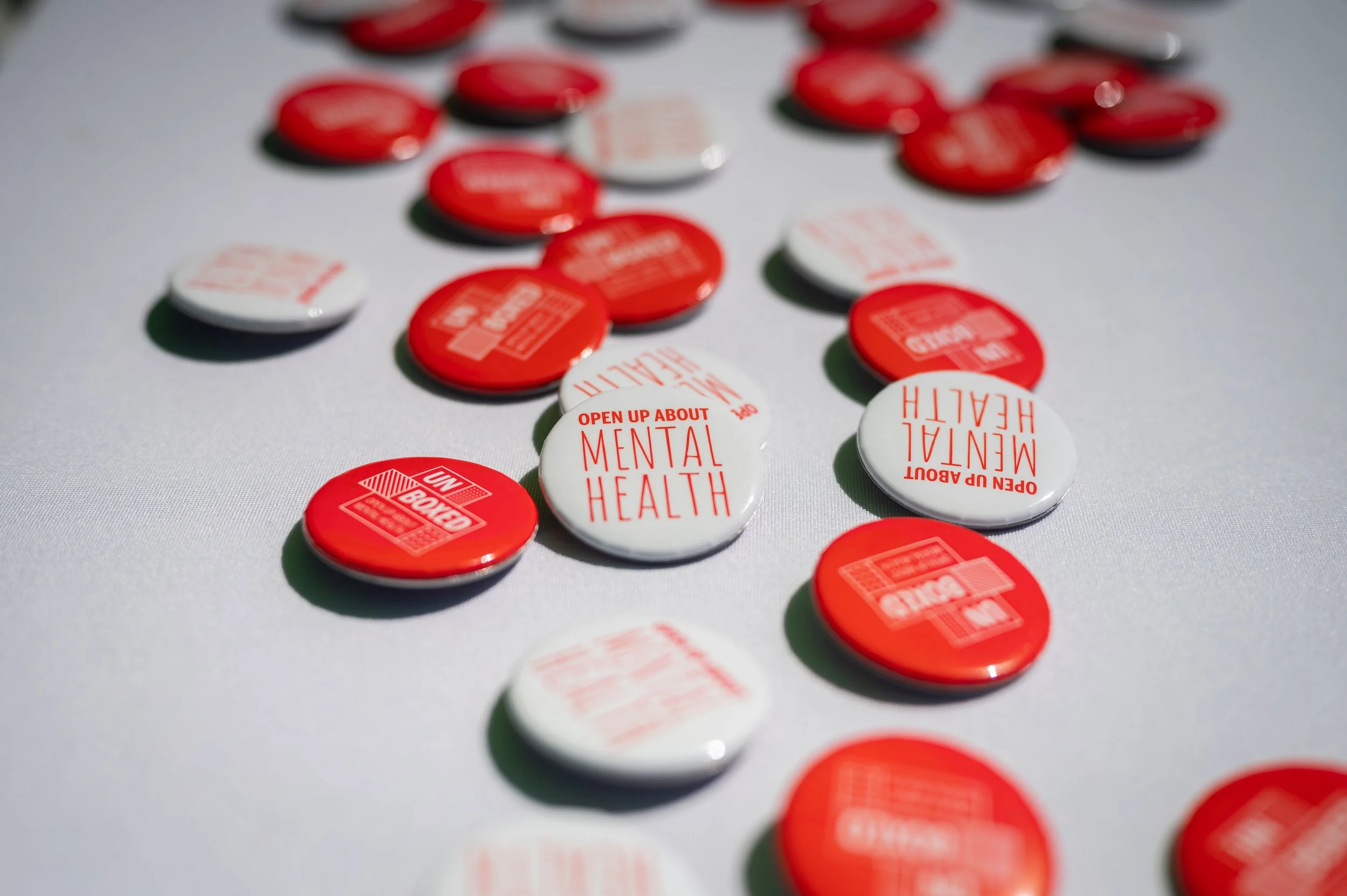red and white metal buttons strewn across a table