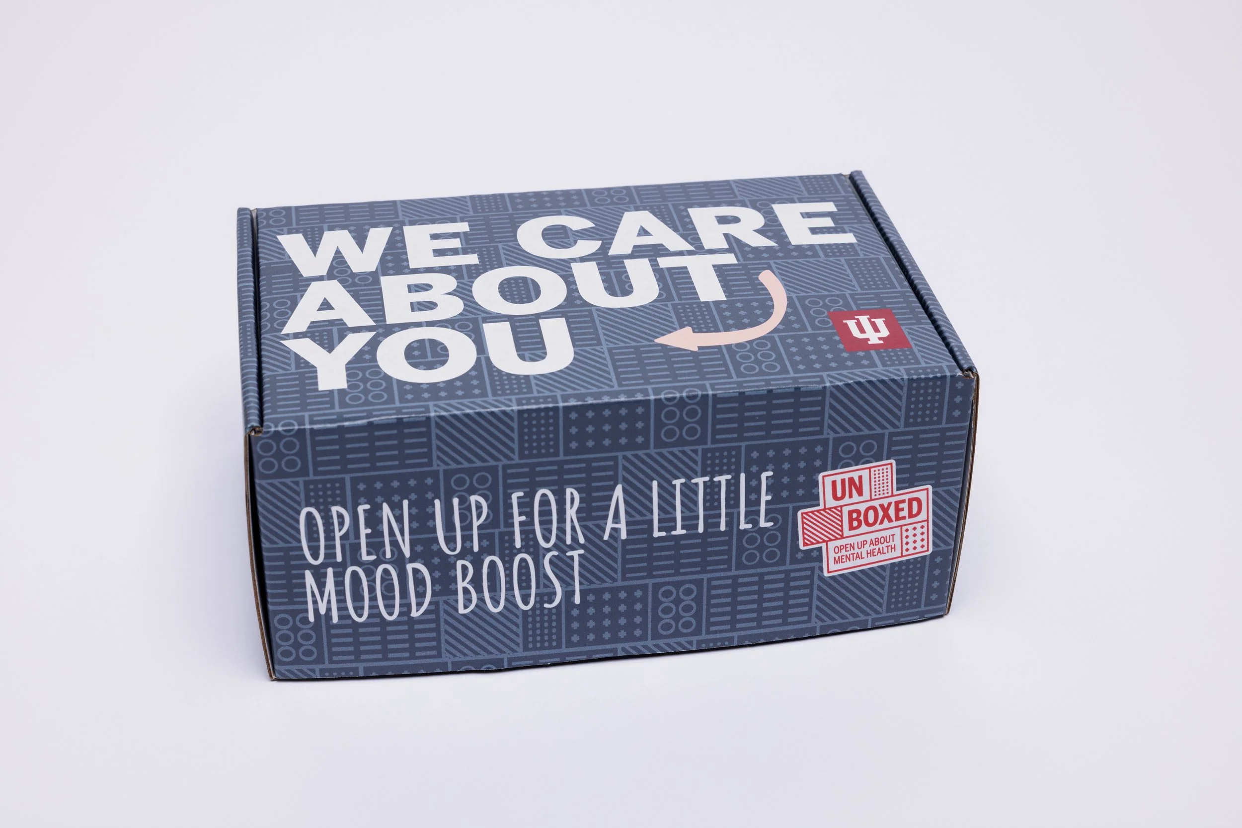 a blue patterned box reading "We care about you. Open up for a little mood boost"