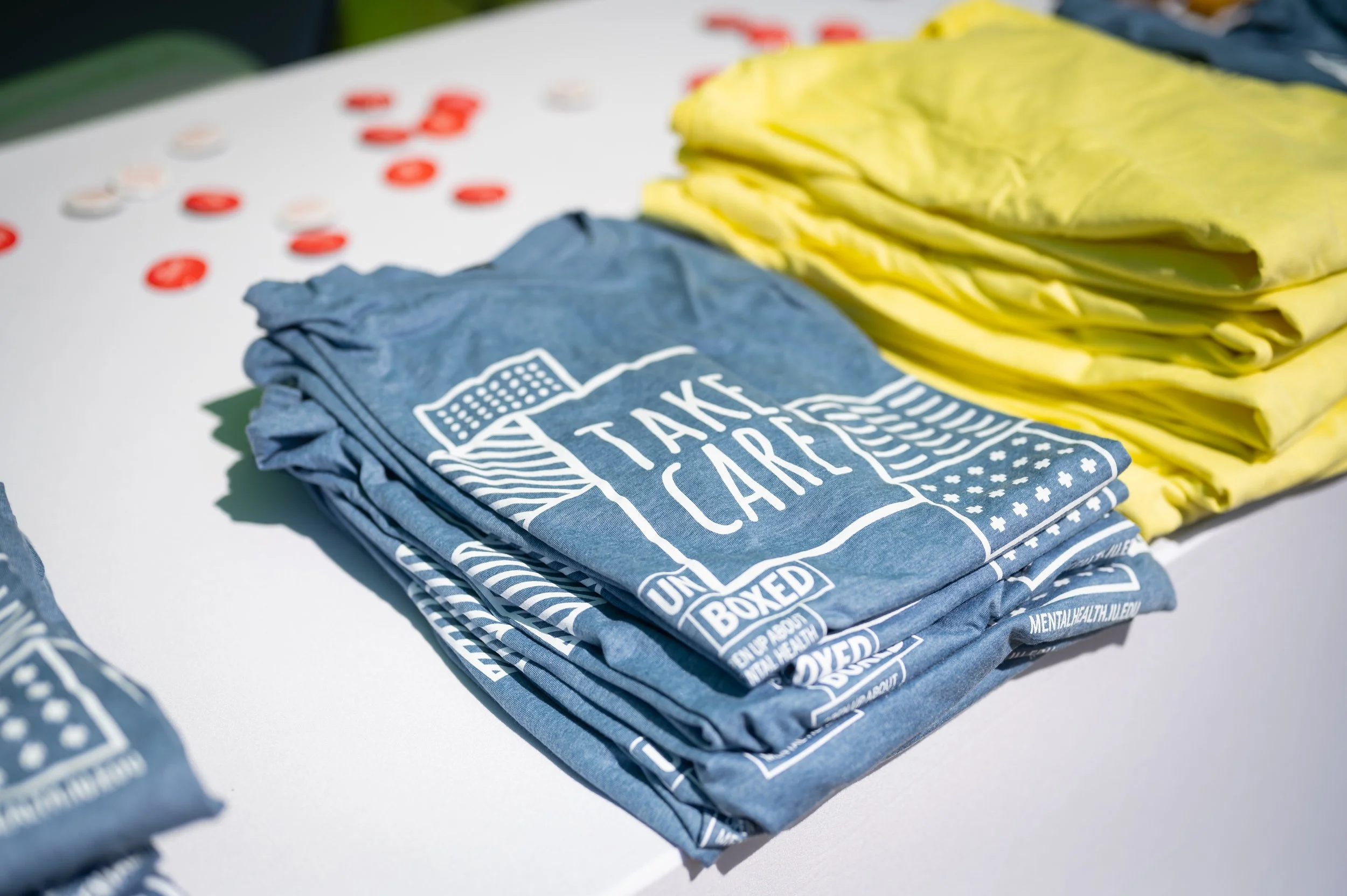 stacks of blue and yellow t-shirts on a table
