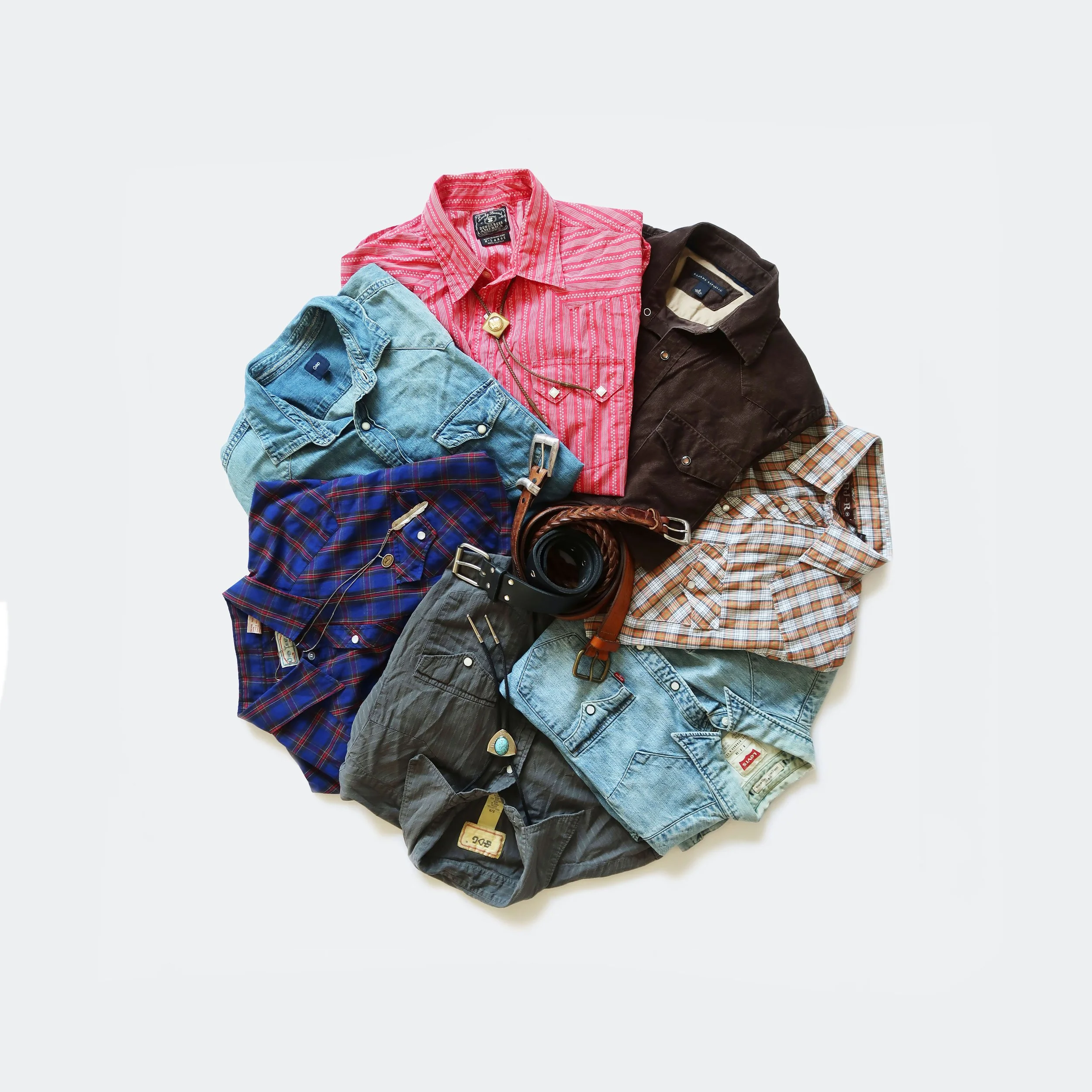 A collection of men's clothing including jeans, shirts, and jackets, with a belt and jewelry, arranged on a white background.