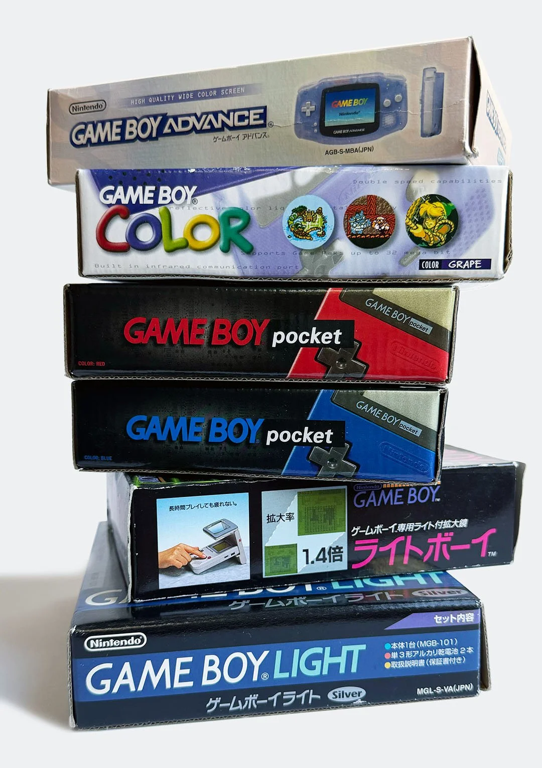 Stack of six vintage Nintendo handheld gaming device boxes, including Game Boy Advance, Game Boy Color, Game Boy Pocket, Game Boy Light, and accessories.
