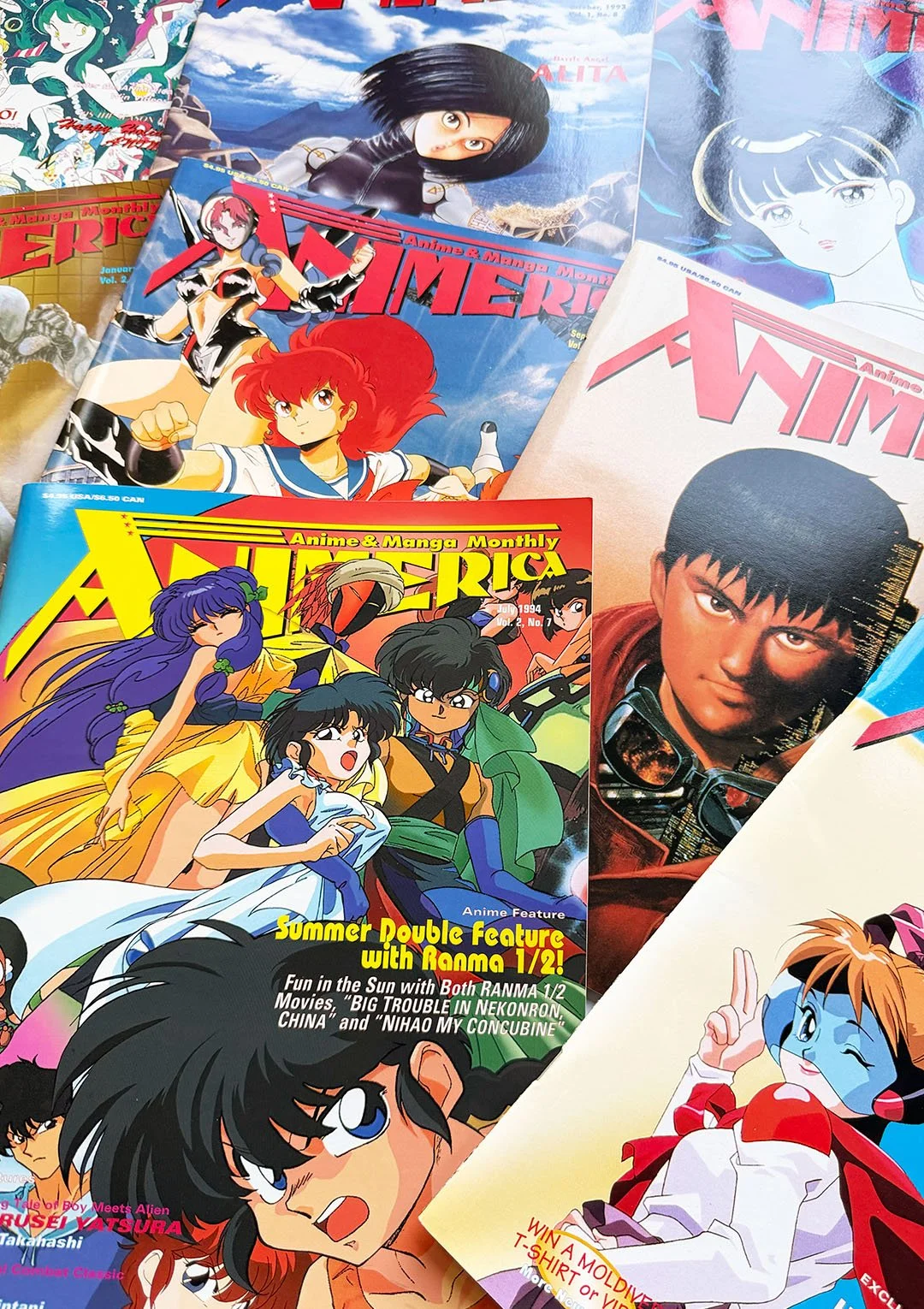 Multiple vintage anime and manga magazines featuring colorful illustrated covers, including characters with various expressive poses and styles, layered on top of each other.