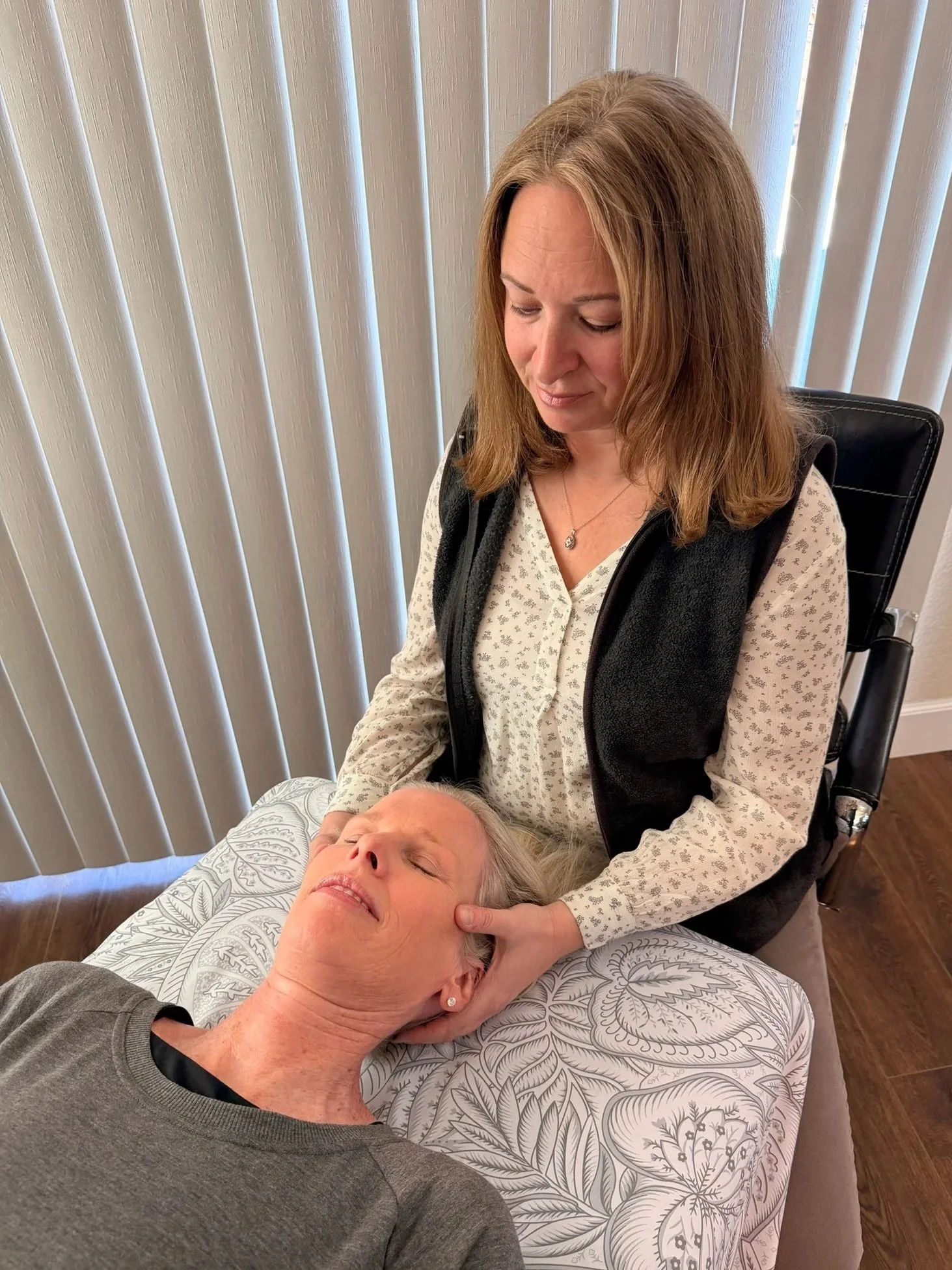 A woman receiving a CranioSacral Therapy treatment at a spa or wellness center.