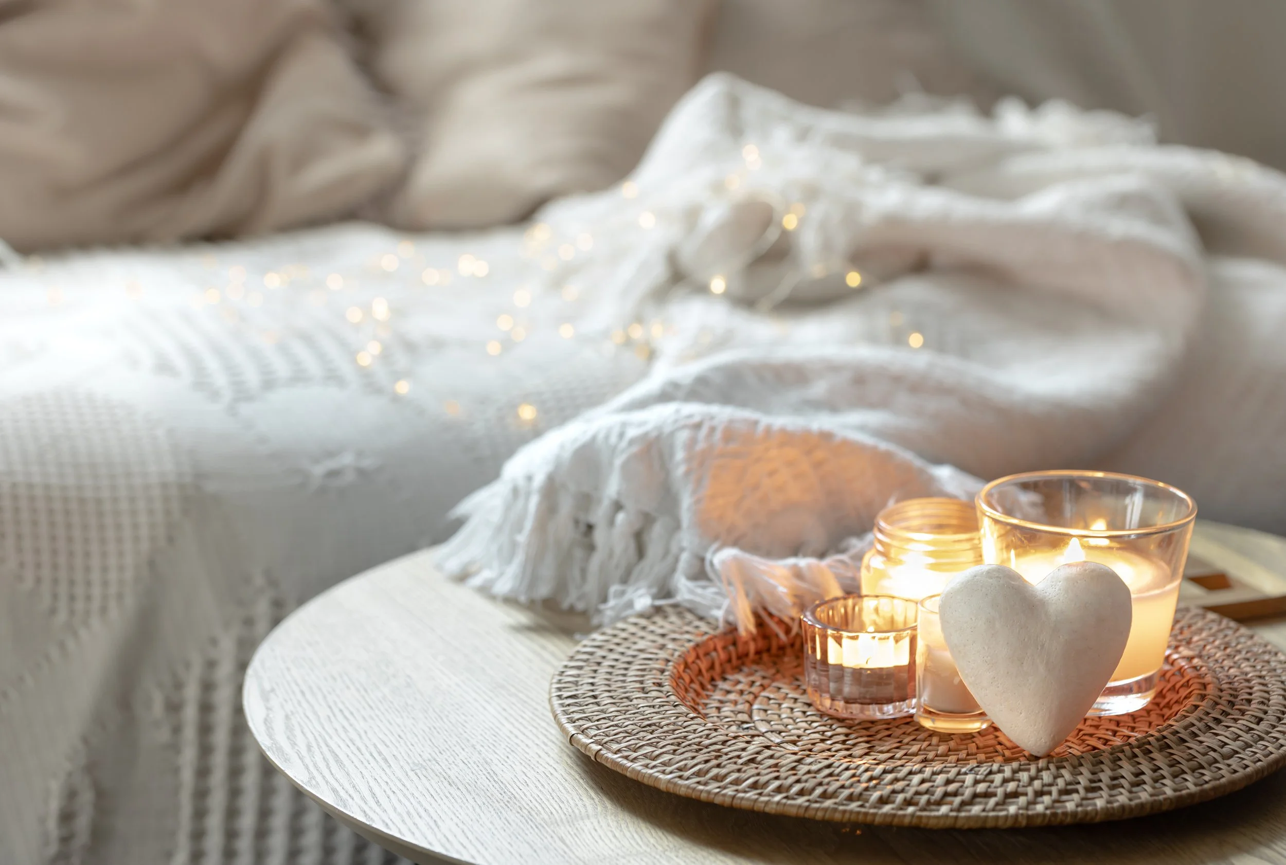 Warming candles in front of a sofa and throw
