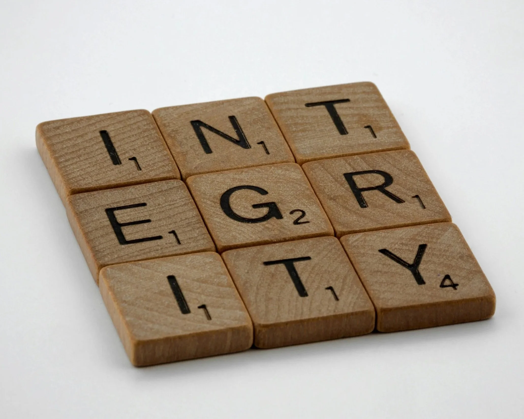 Wooden letter tiles spelling "INTEGRITY," representing living by your own values and rebuilding identity after an adult ADHD diagnosis.