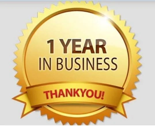 A gold badge with the text "1 Year in Business" and a red banner with "Thank You!"