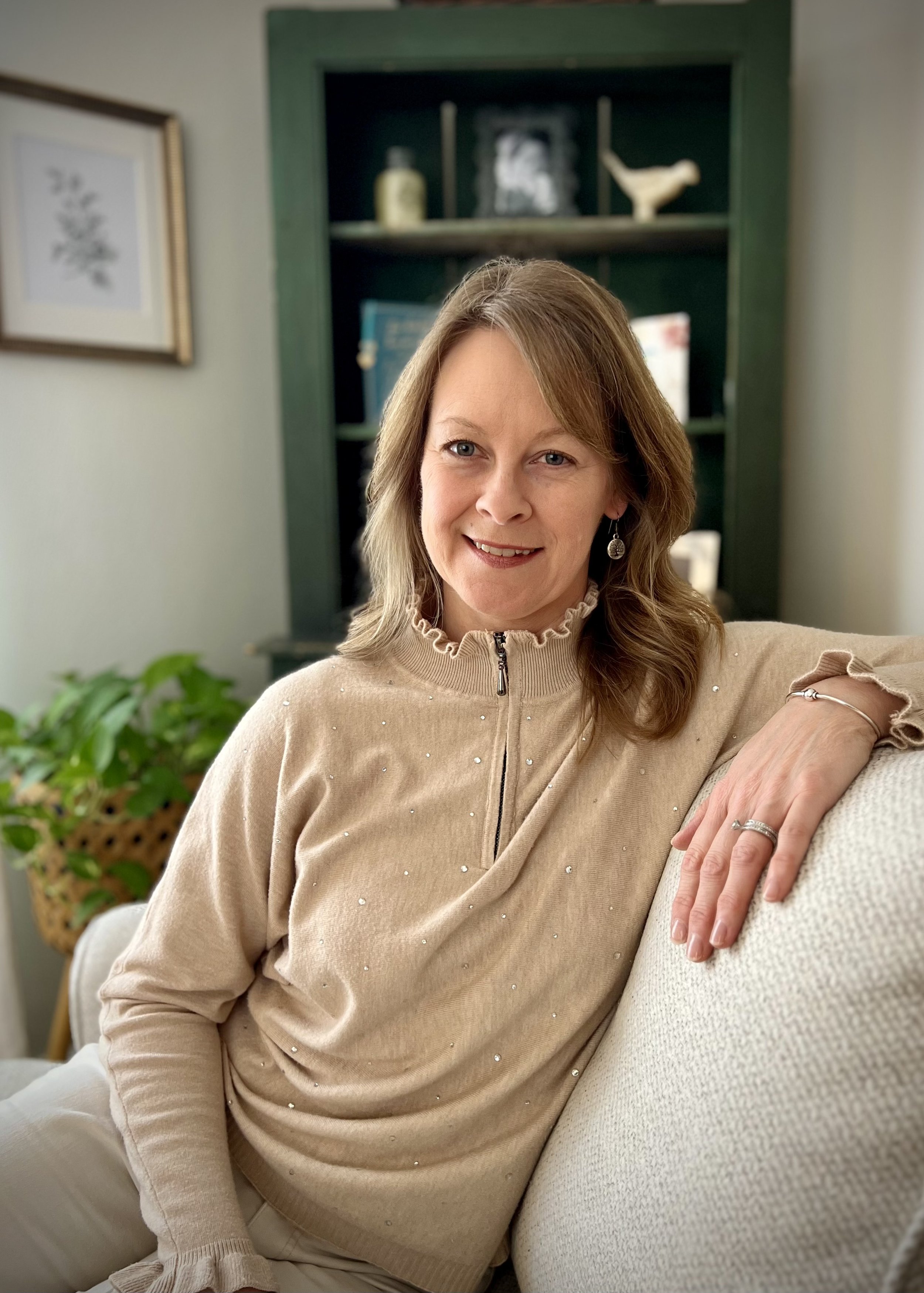 Headshot of Holly W Smith LICSW sitting on a comfortable chair smiling