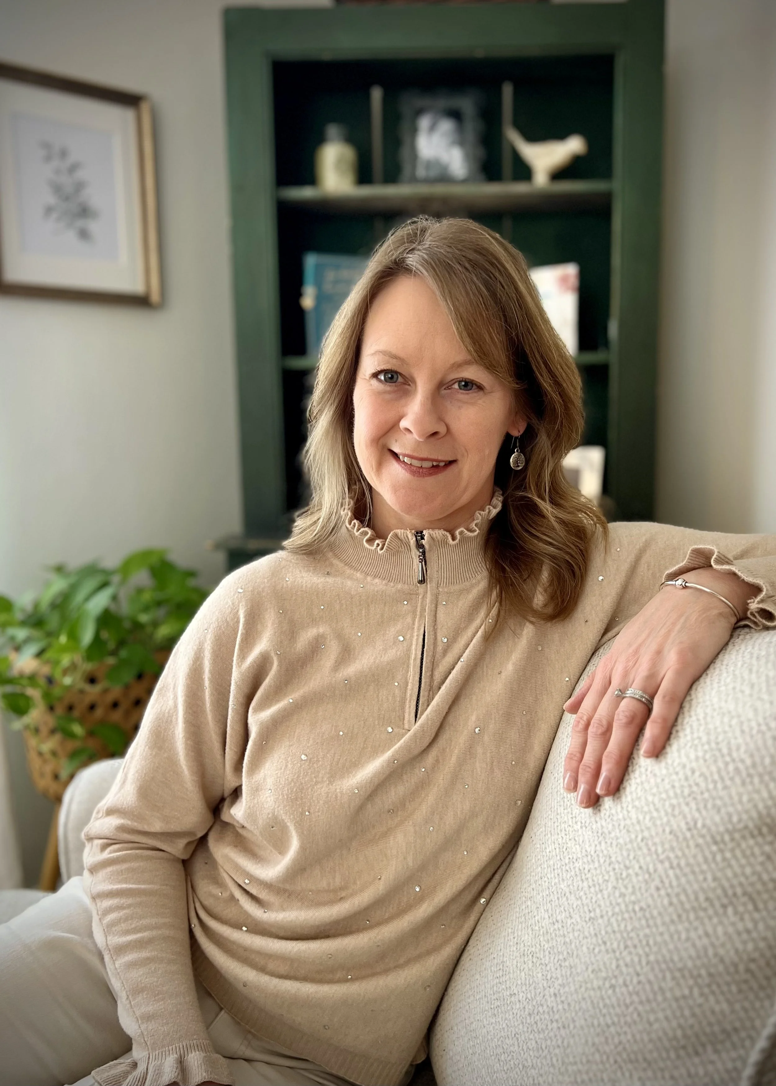Headshot of Holly W Smith LICSW sitting on a comfortable chair smiling