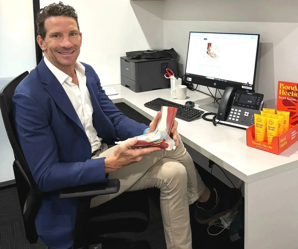 Ben Holland, podiatrist and founder of Bondi Heels, at his clinic desk