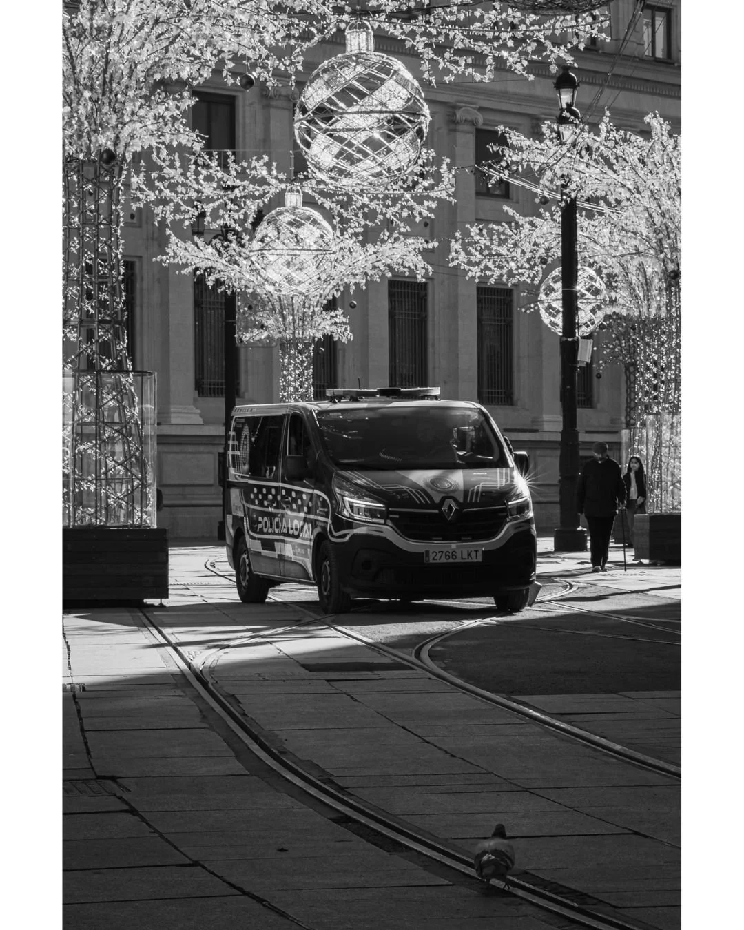 December draped in light and shadow&hellip;
the city moving slowly beneath its winter shimmer.

Diciembre envuelto en luces y sombras&hellip;
la ciudad avanzando despacio bajo su brillo invernal.

#streetphotography #bnwstreet #urbanstory #sevilleatc