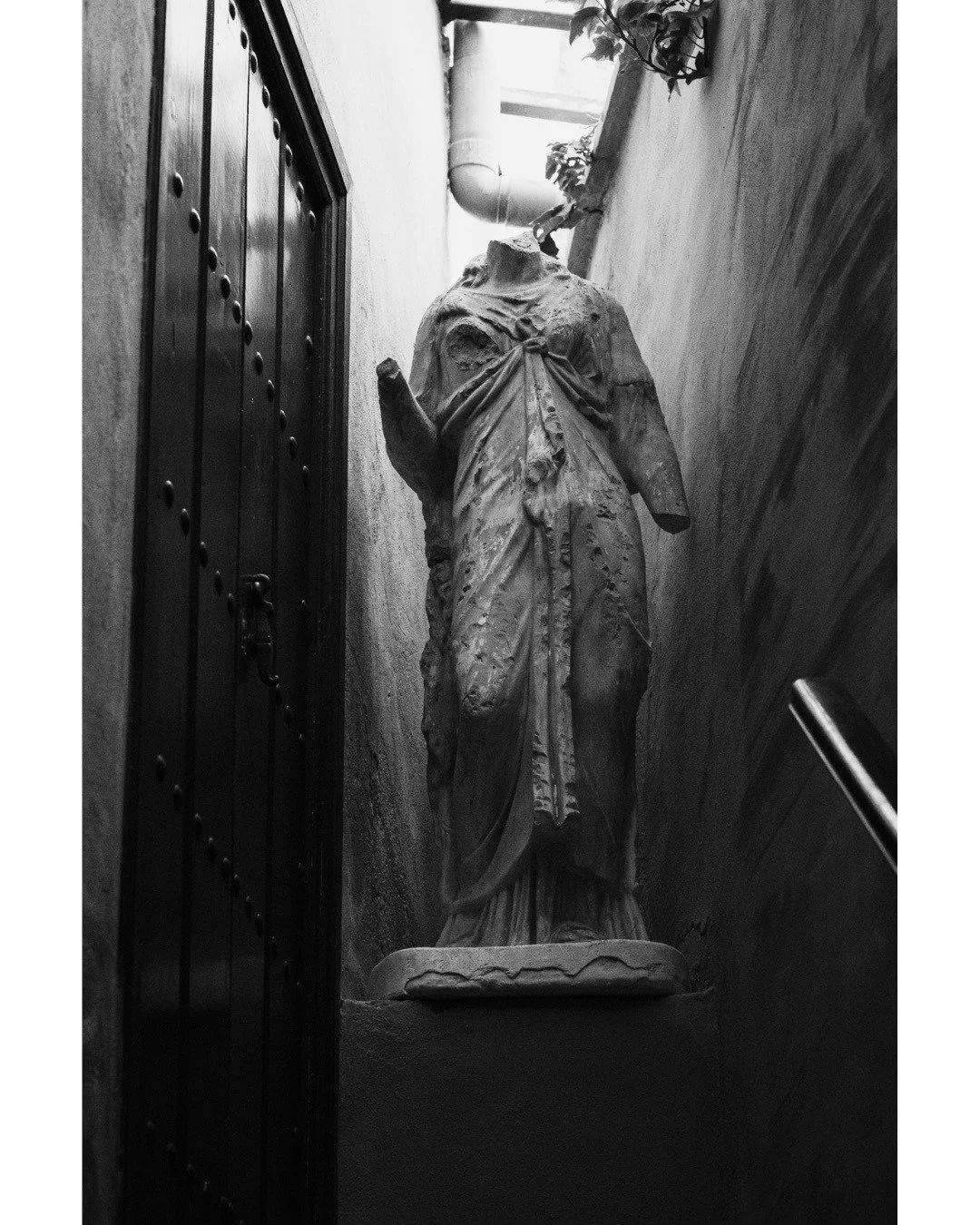 Hidden depths within the stairways of Casa de las Salinas. A quiet, sculpted figure framed entirely by deep shadows and the striking lines of historic Seville.

Rincones ocultos en las escaleras de la Casa de las Salinas. Una figura esculpida que des