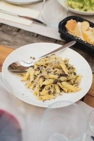 Plate of fettuccine pasta with creamy sauce and black pepper, served with a fork.