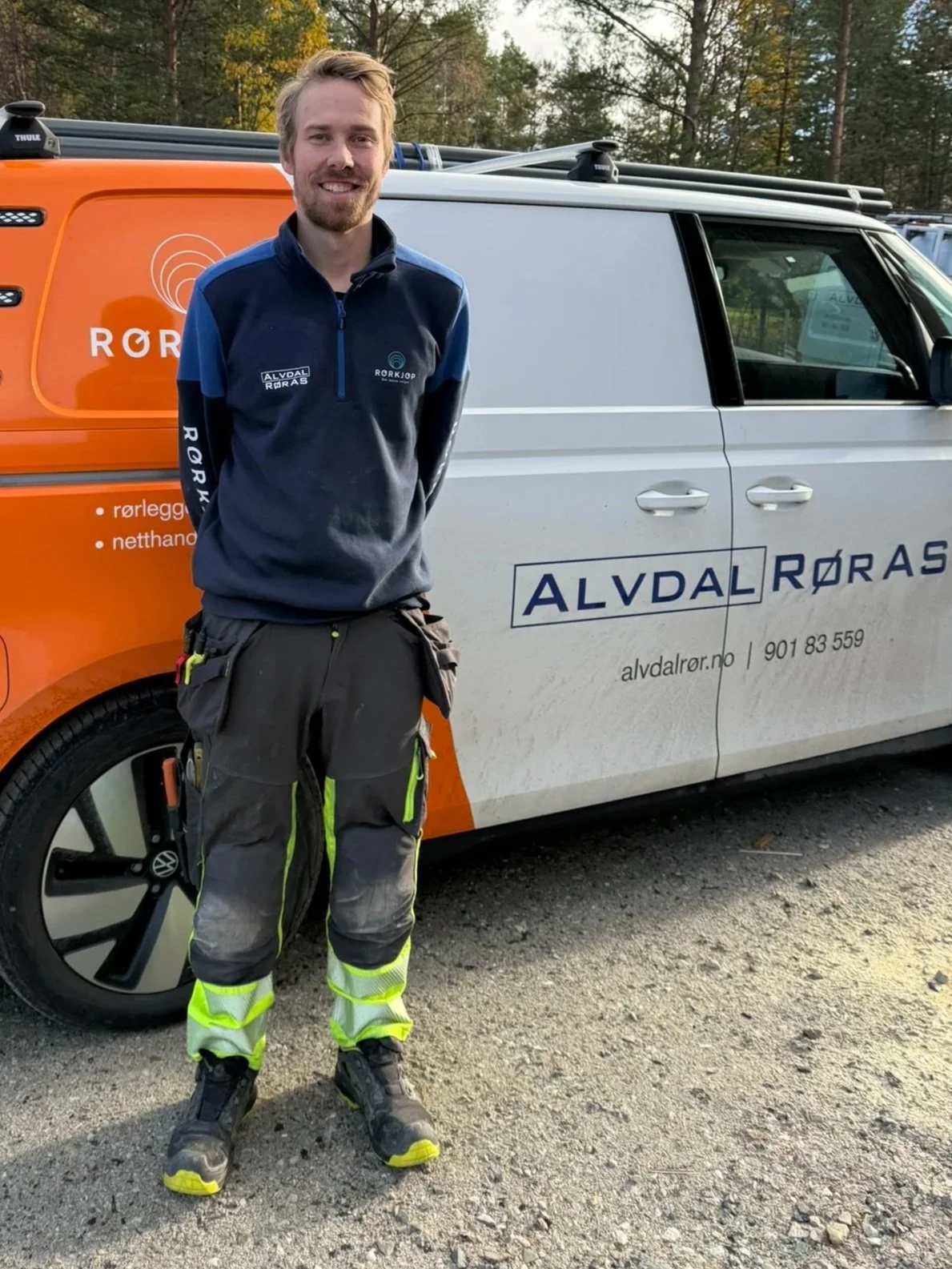 En mann i arbeidstøy står foran en bedriftsbil med logoen til Alvdal Rør AS, et rørleggerfirma, i en utendørs setting.