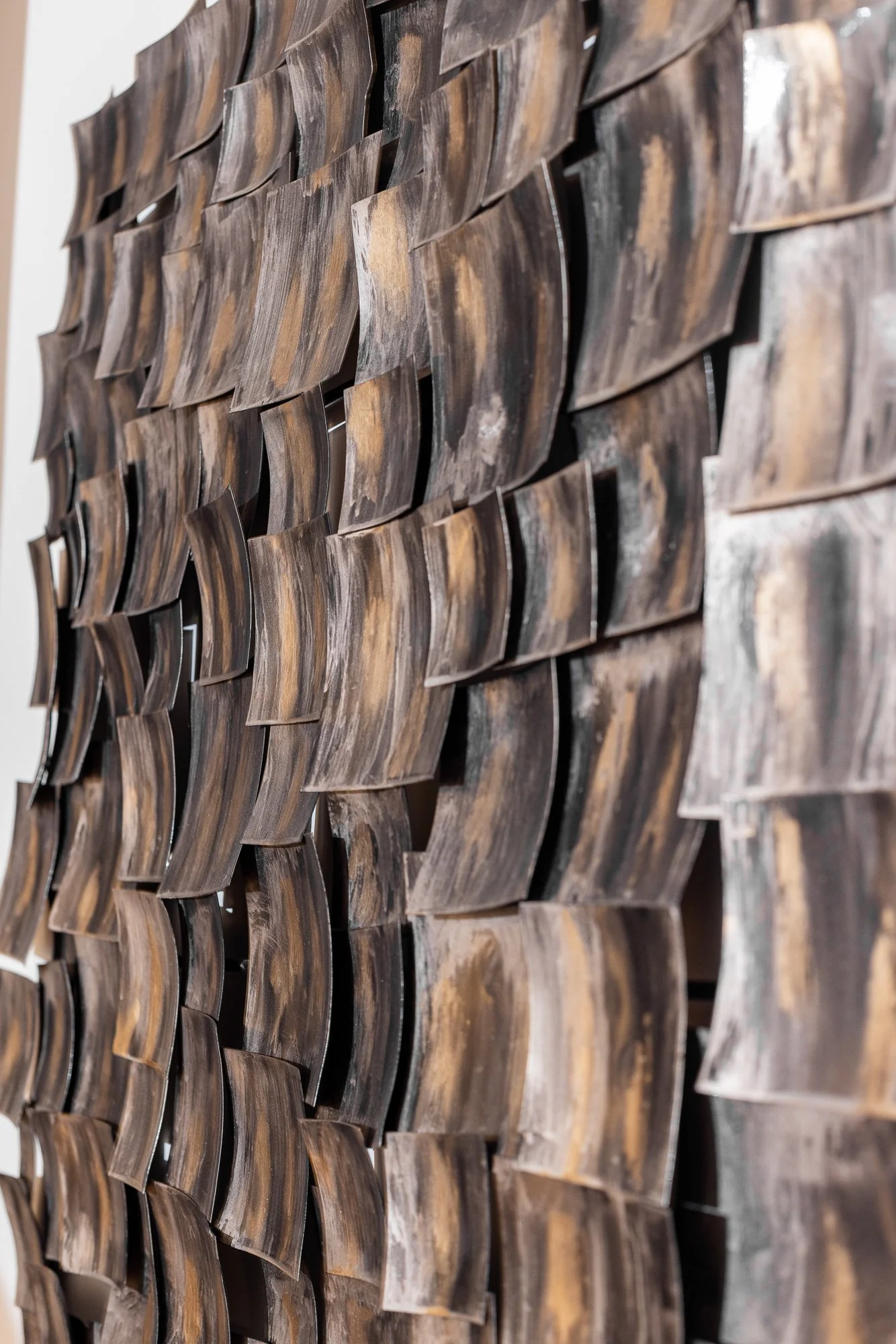 Close-up of a decorative wall feature made of curved, textured wooden pieces arranged in a pattern.