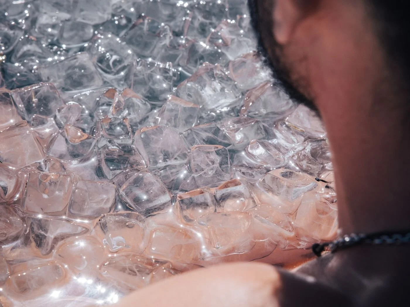 Nahaufnahme von einem Menschen, der Eiswürfel betrachtet.