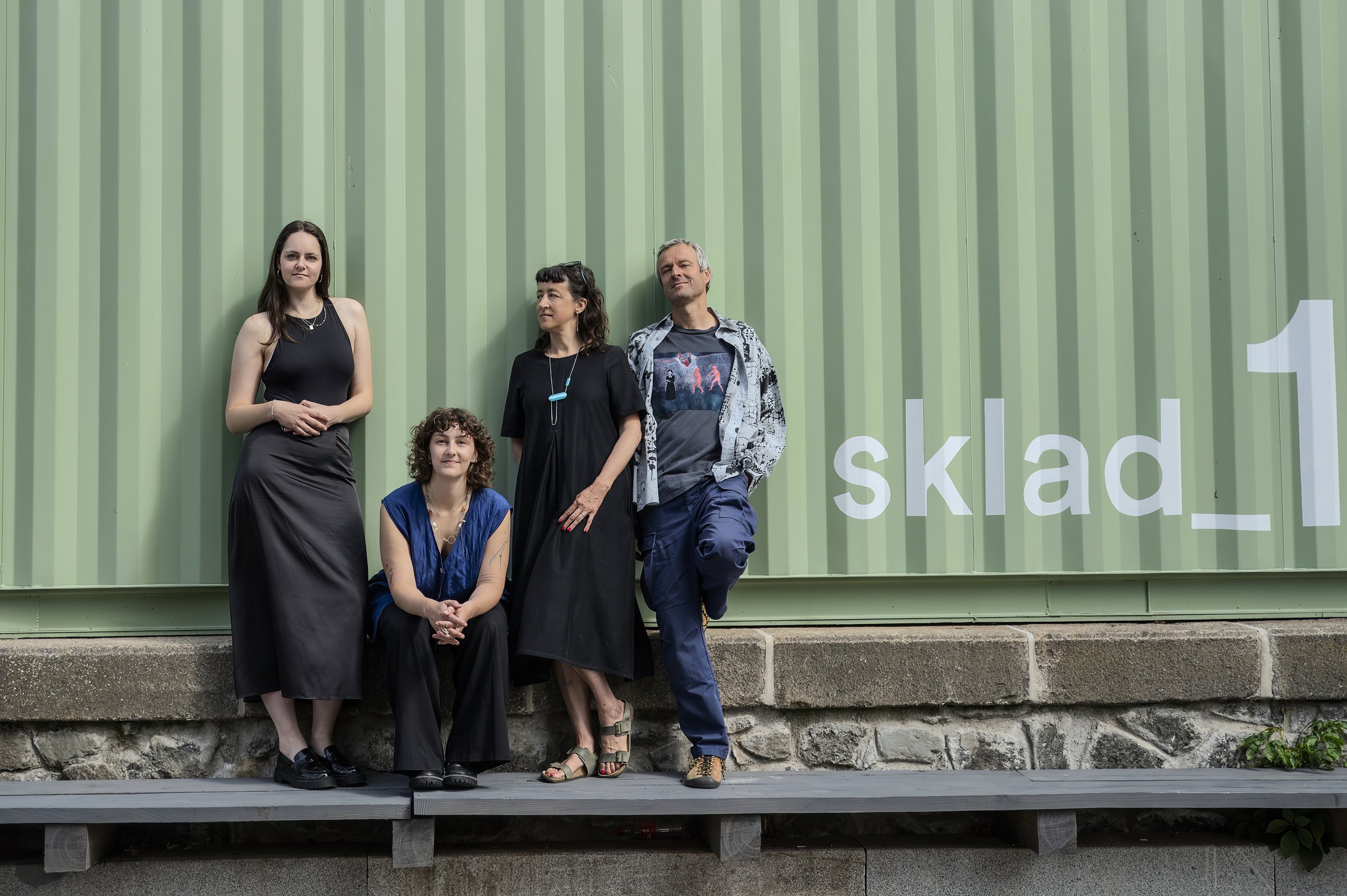 Skupina lidí stojících u kontejneru, týmová lifestyle fotografie vhodná pro firemní kulturu nebo komunitní projekty.