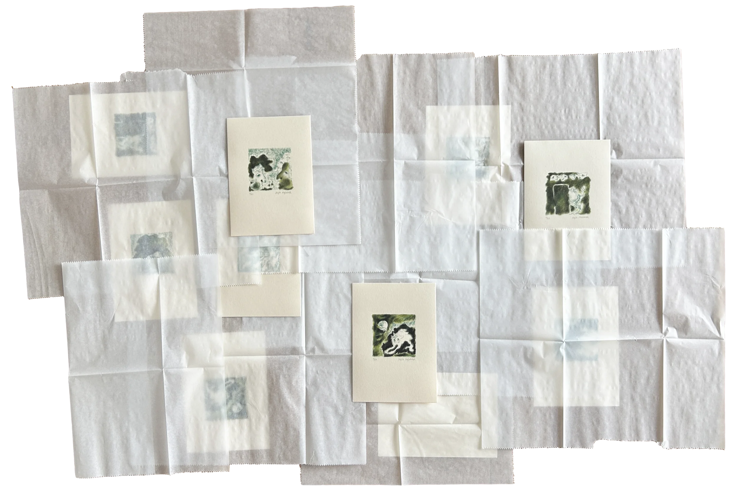 Collection of small art prints and tissue papers on a flat surface, with three small watercolor artworks depicting abstract or nature-inspired scenes.