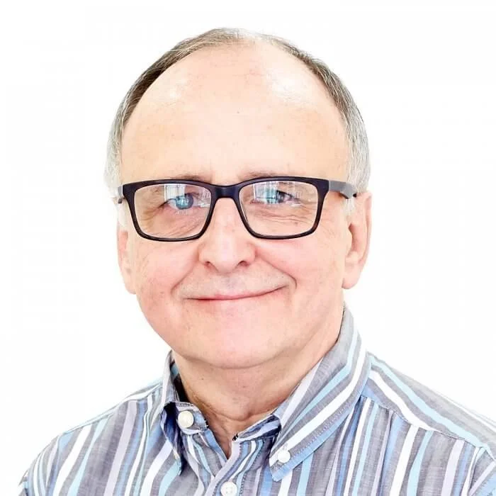 A photo of Richard who is wearing glasses and a stripy shire.