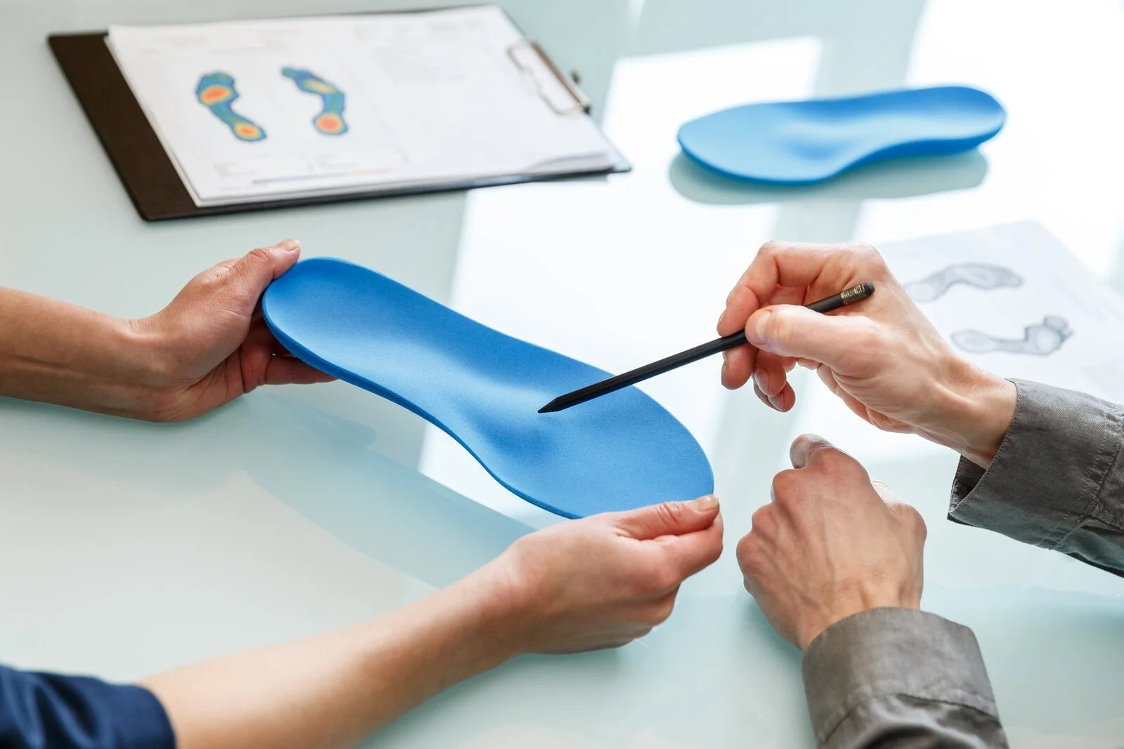 Podiatrist chiropodist consulting patient about custom orthotics — gait analysis, foot scan and orthotic fitting; expert chiropodist care, pain relief and posture support by Canadian Foot Clinic & Orthotic Centre, St. Catharines ON.