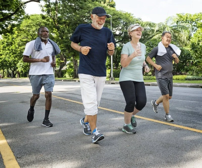 Active adults jogging in park, pain free stride; gait support, injury prevention, custom orthotics and foot care by registered chiropodist Canadian Foot Clinic & Orthotic Centre, St. Catharines ON.