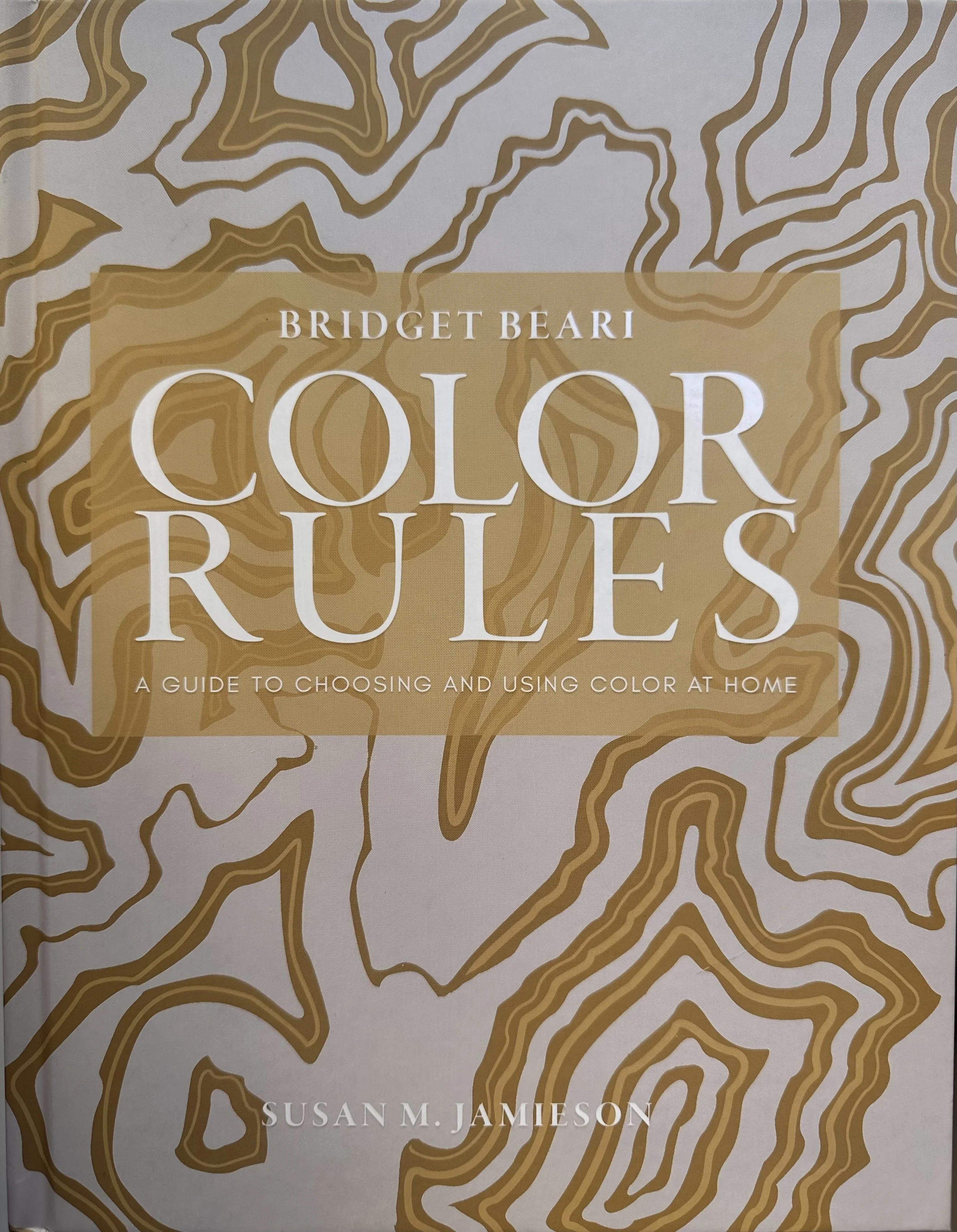 Book cover titled 'Color Rules: A Guide to Choosing and Using Color at Home' by Bridget Beari and Susan M. Jamieson. The cover features abstract, layered, contour-like lines in shades of brown and beige, resembling a topographical map.