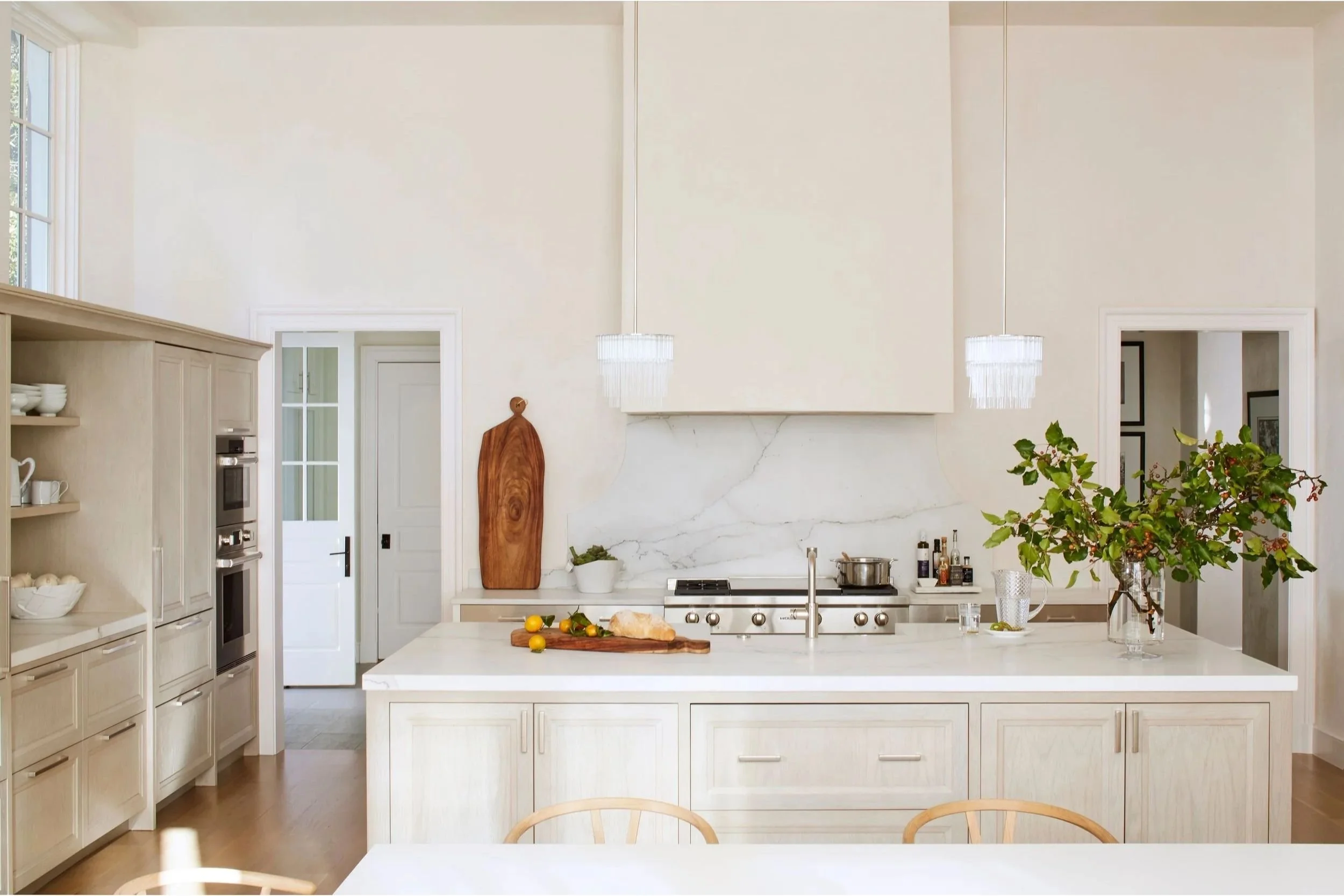 Creamy white walls and island accent natural light streaming into this modern kitchen.
