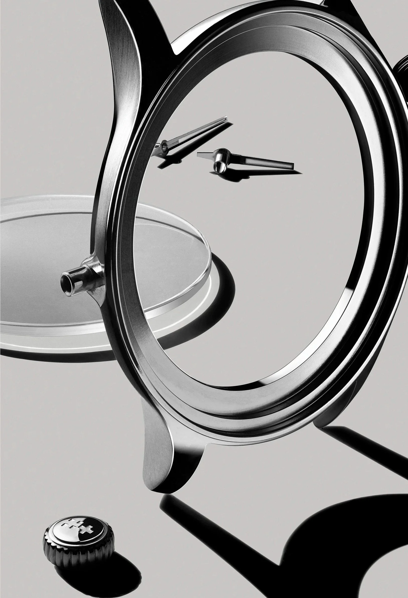 A close-up of a vintage stainless steel alarm clock with a mirror face, showing the time at approximately 3:15, along with a small round alarm button with a plus sign on it.