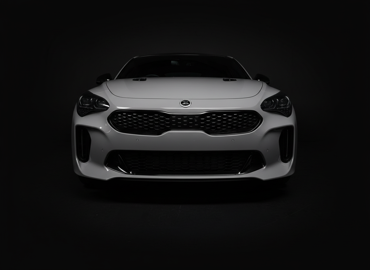 Front view of a white sports car with black grille and headlights on a dark background.