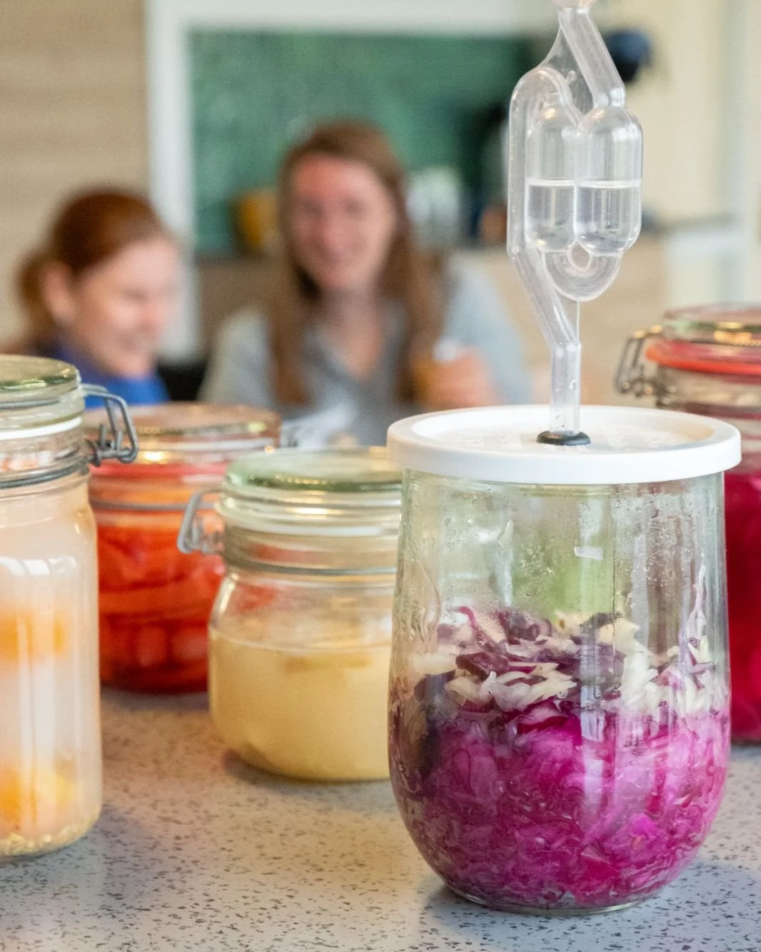 Lampen met ingelegde bloemen en een sessie met twee lachende vrouwen op de achtergrond.