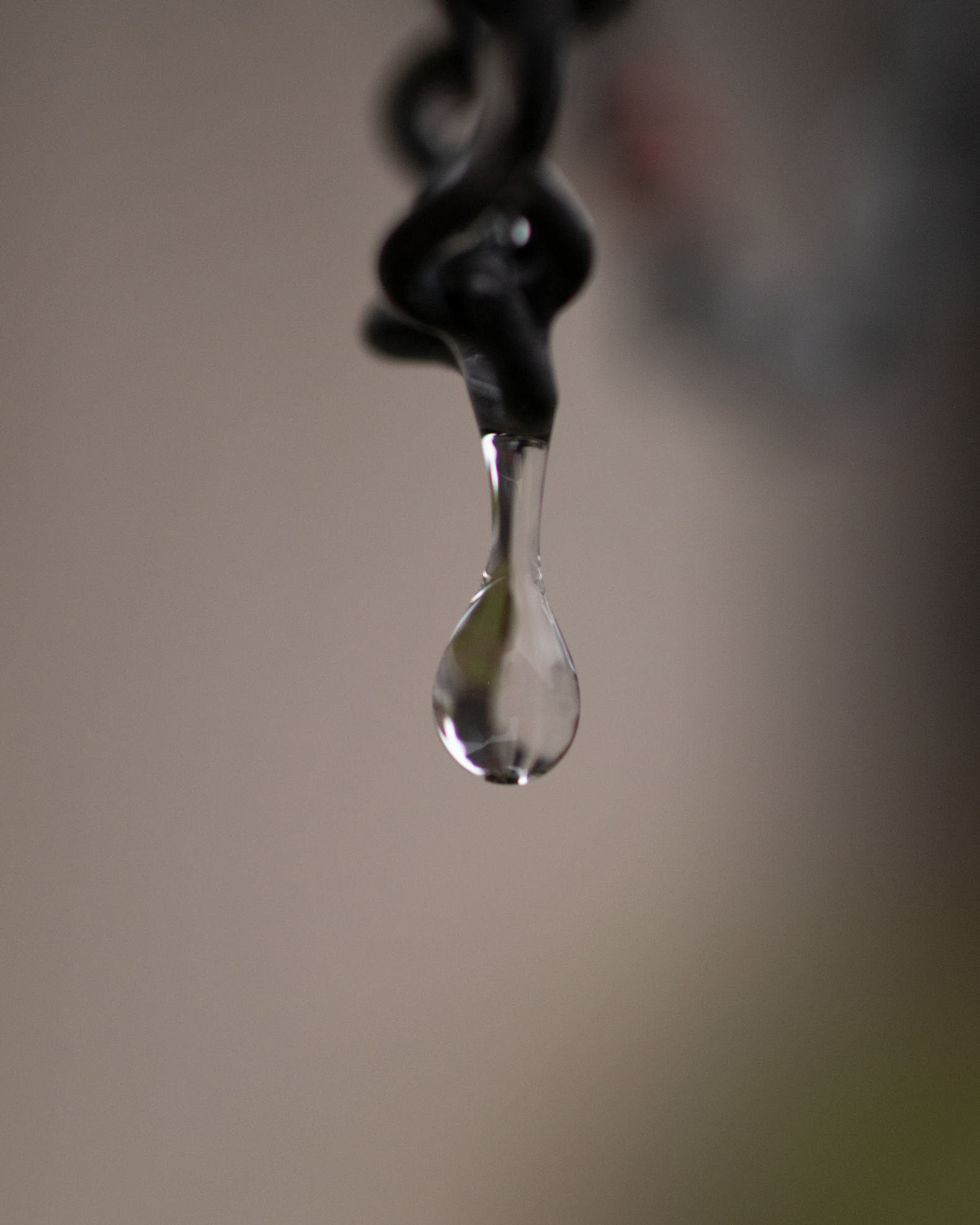 Goutte d'eau suspendue à une chaîne.