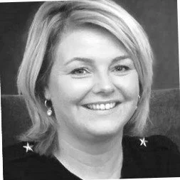 Zicht op een glimlachende vrouw met blond haar en oorbellen, zwart-wit foto.