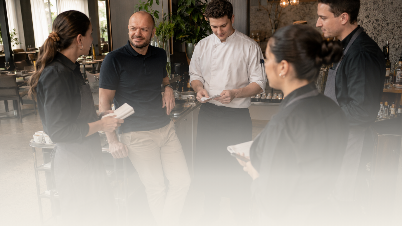 Hotelmanagementteam bespreekt operationele prioriteiten tijdens een dagelijkse briefing.