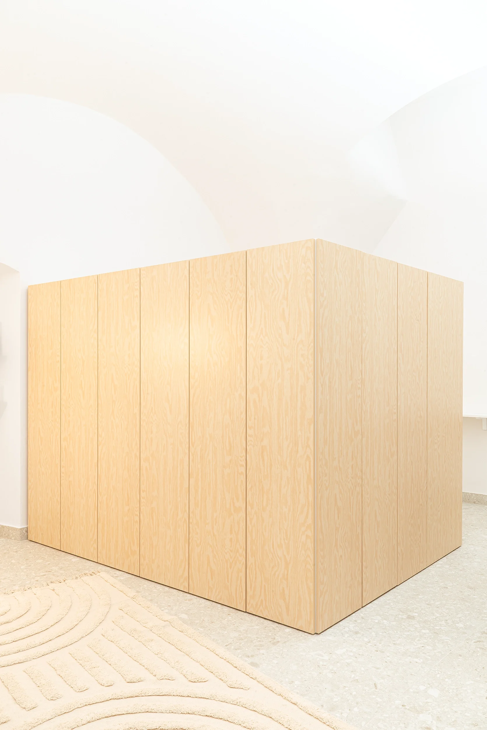 Mobili in legno chiaro all'interno di una stanza bianca.