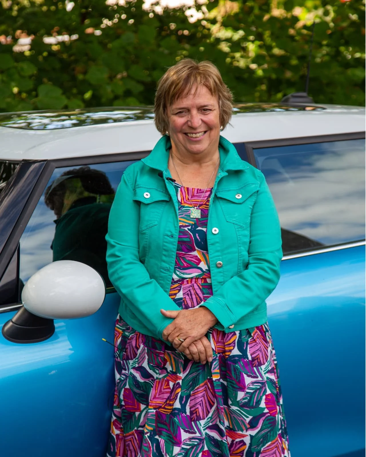 Volunteer driver Gill standing beside her car